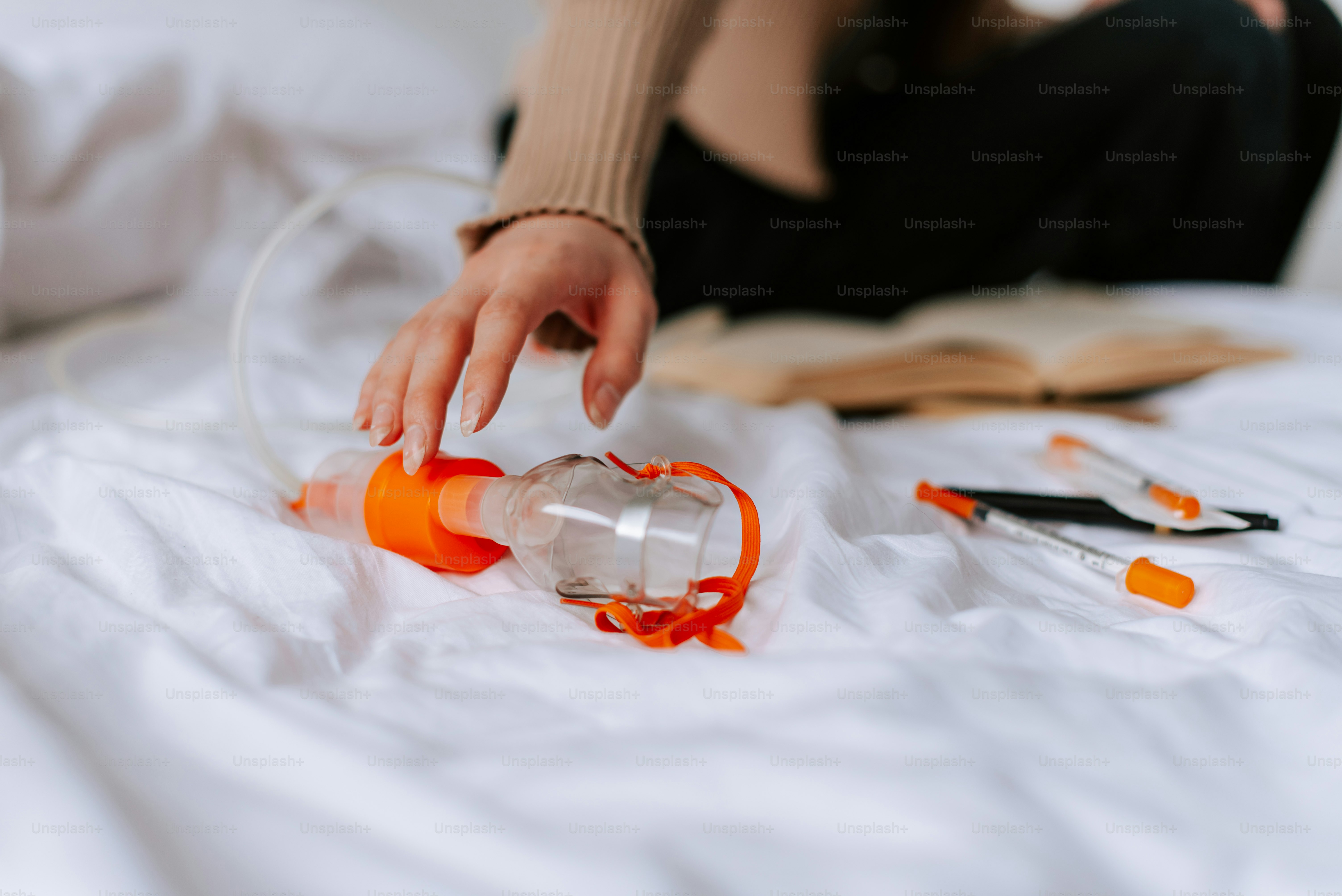 a person is reaching for an empty bottle on a bed