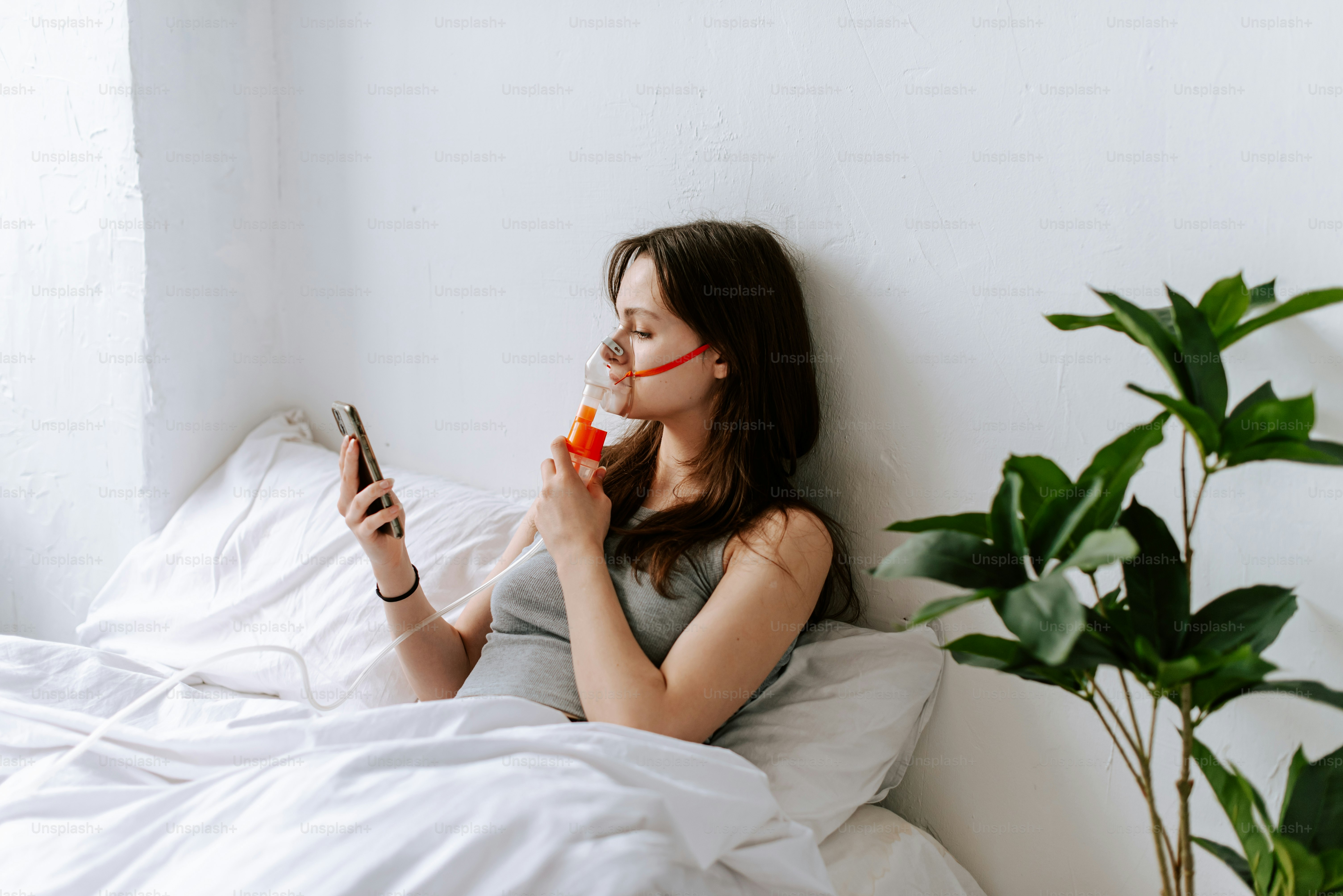 a woman laying in bed with a cell phone