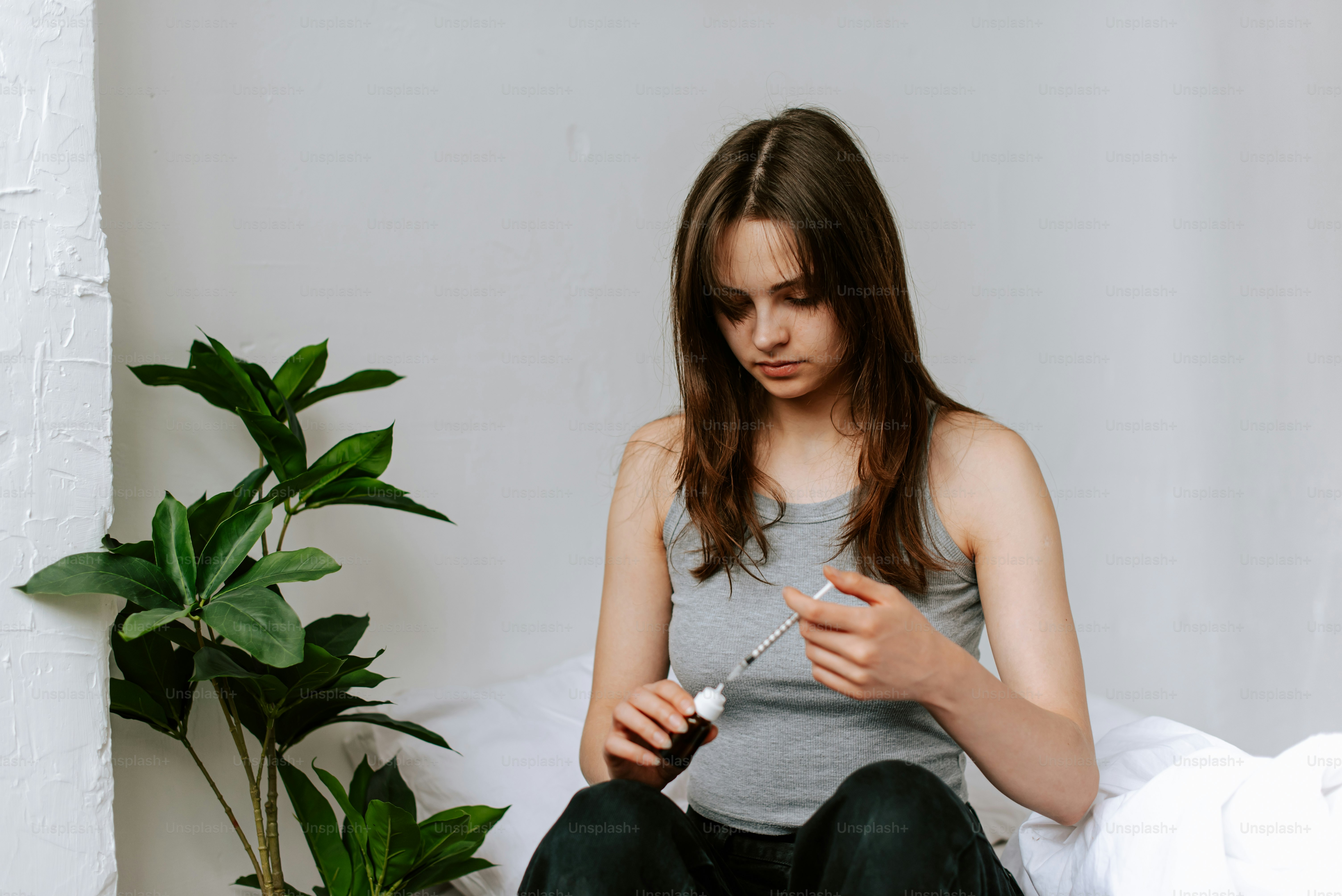 a woman sitting on a bed holding a cigarette