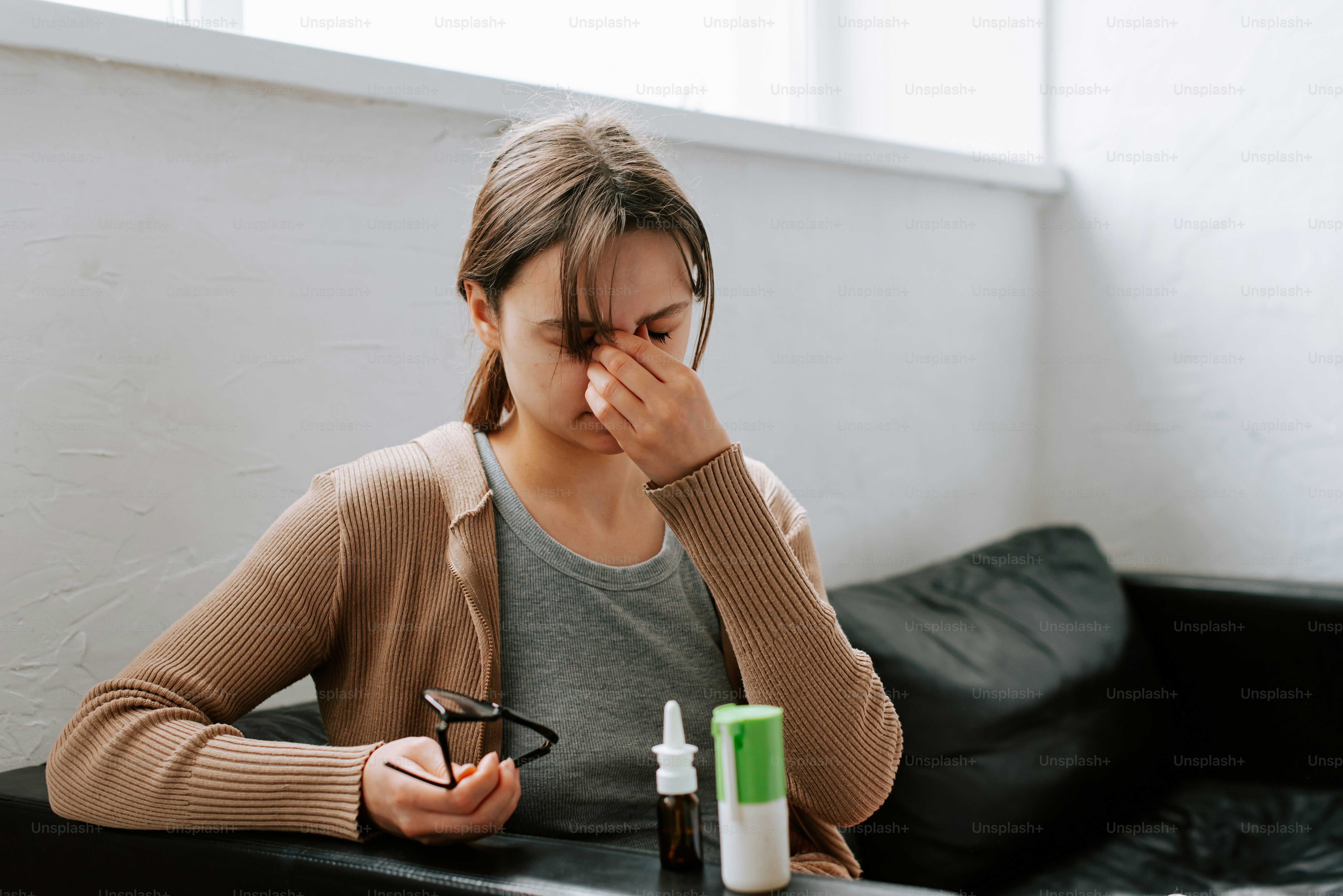a woman sitting at a table with a bottle of medicine