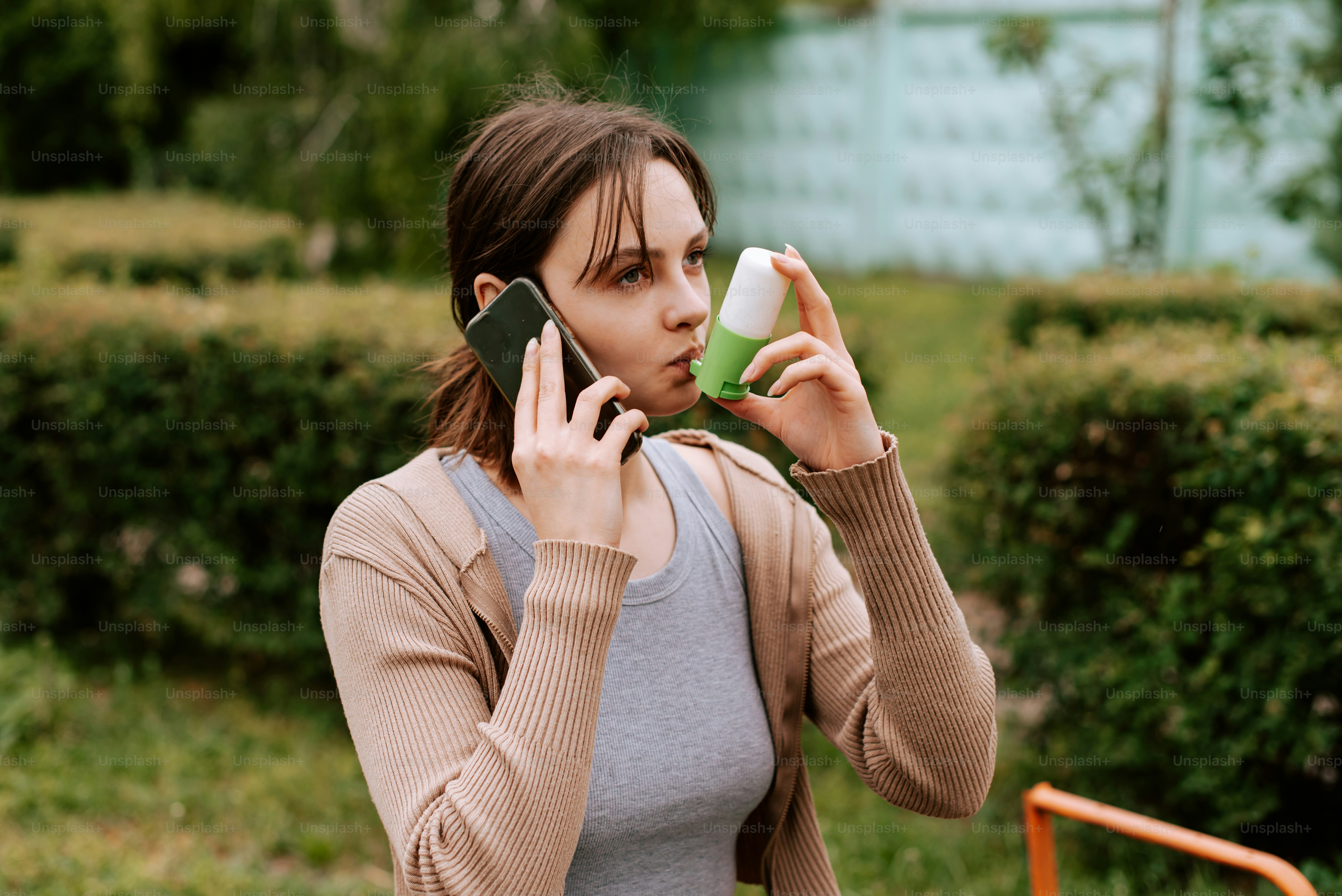 a woman talking on a cell phone while holding a cup
