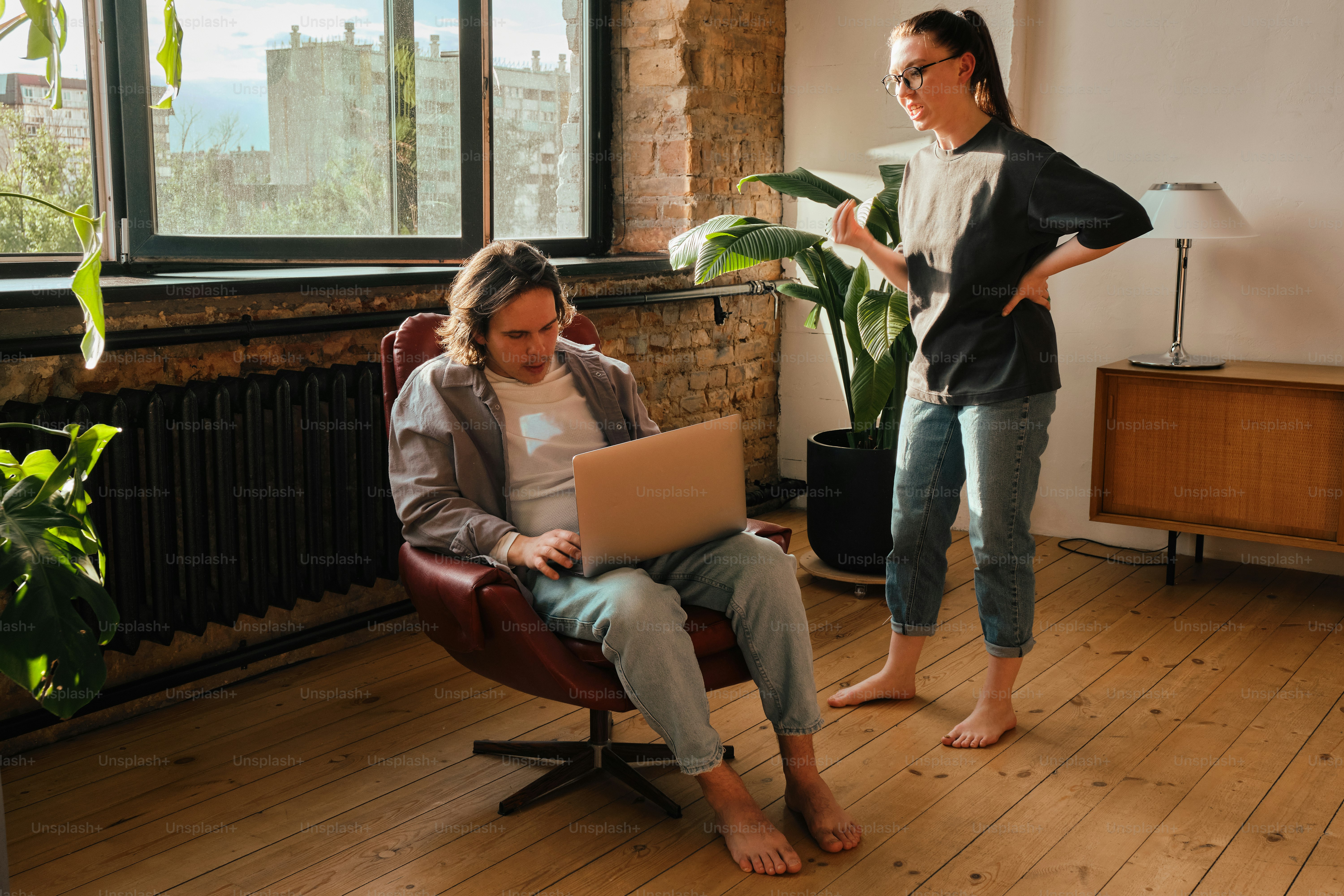 a woman standing next to a woman sitting in a chair
