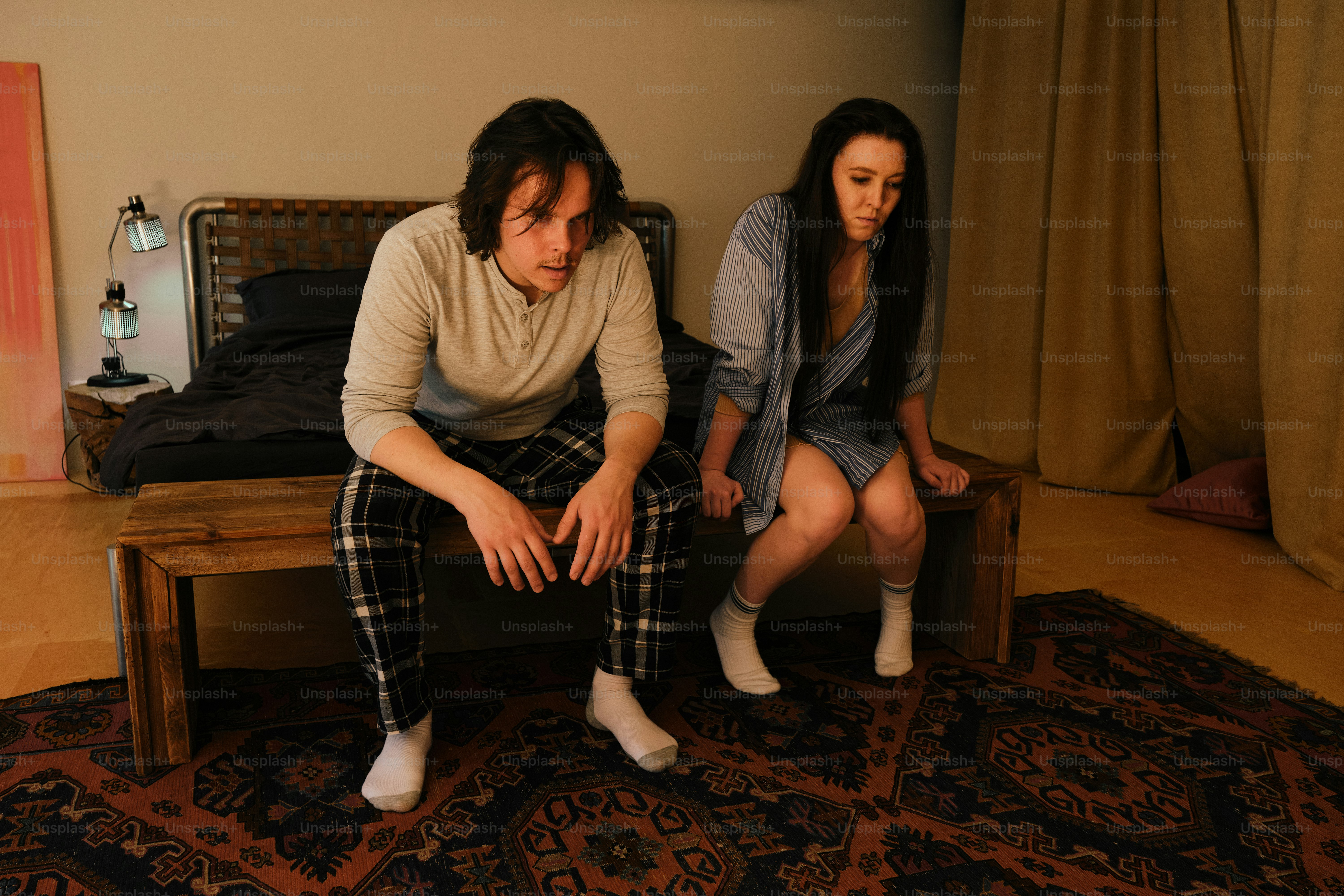 a man and a woman sitting on a bed