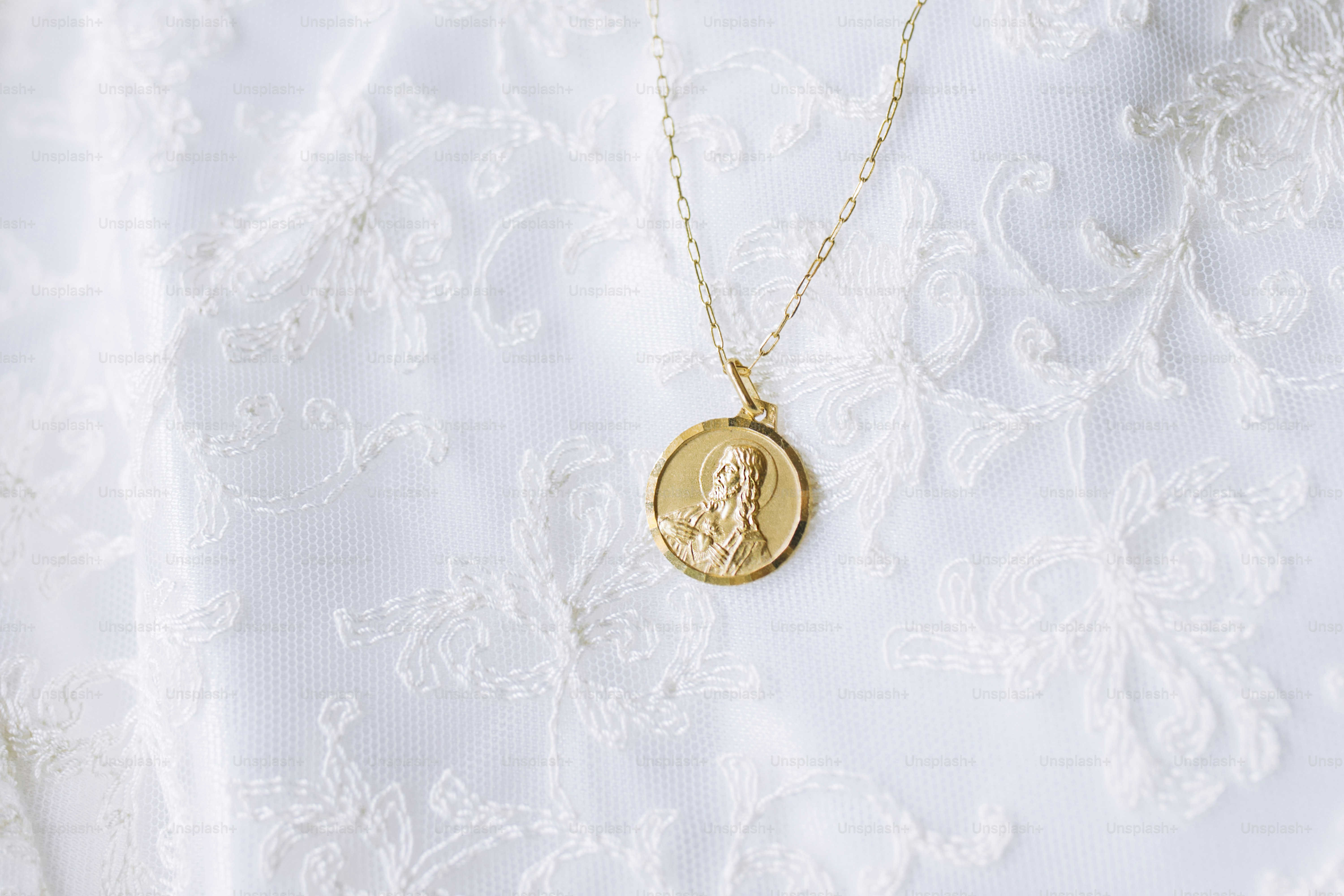 a close up of a gold necklace with a woman's face on it