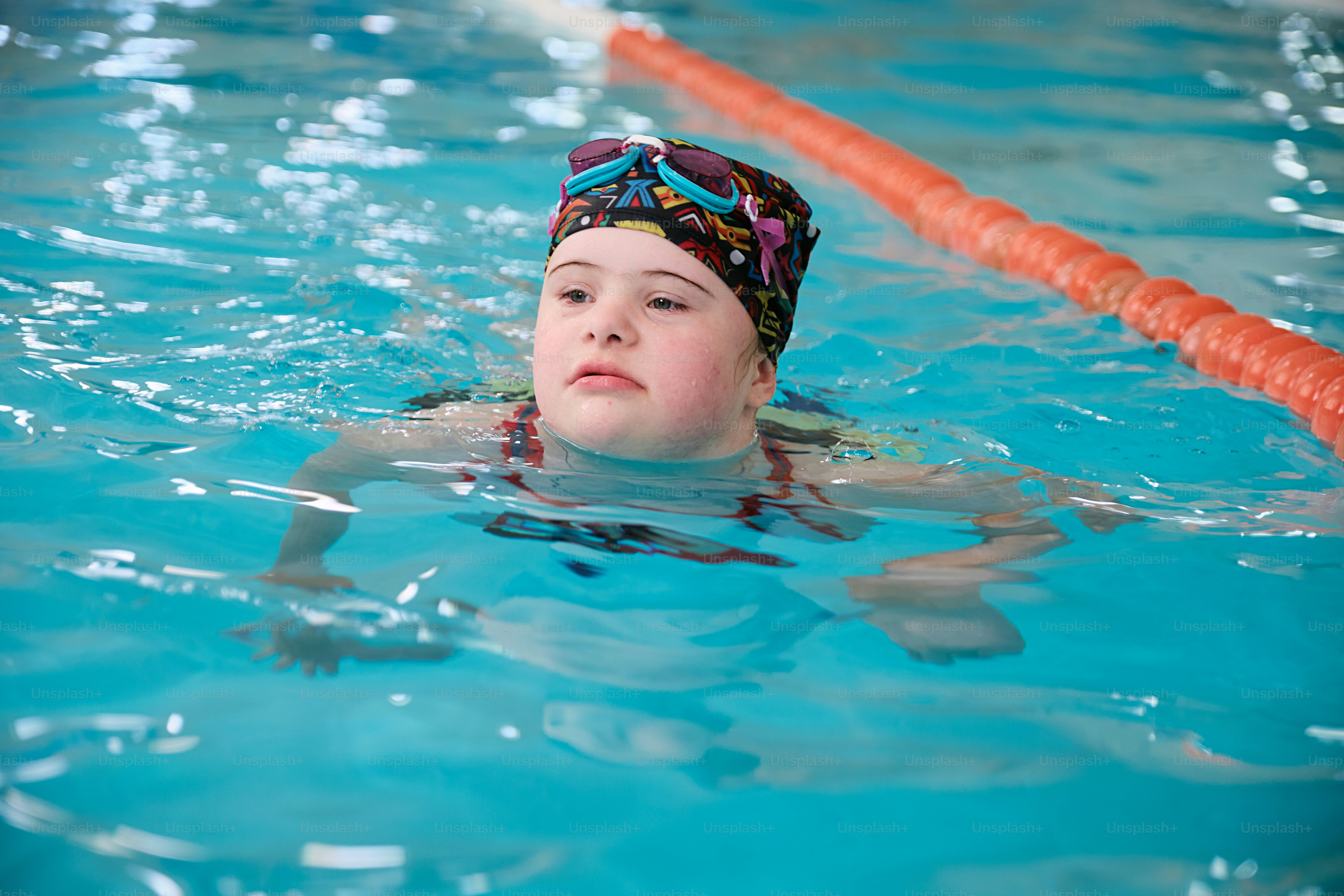 a girl swimming in a pool with a swimming cap on