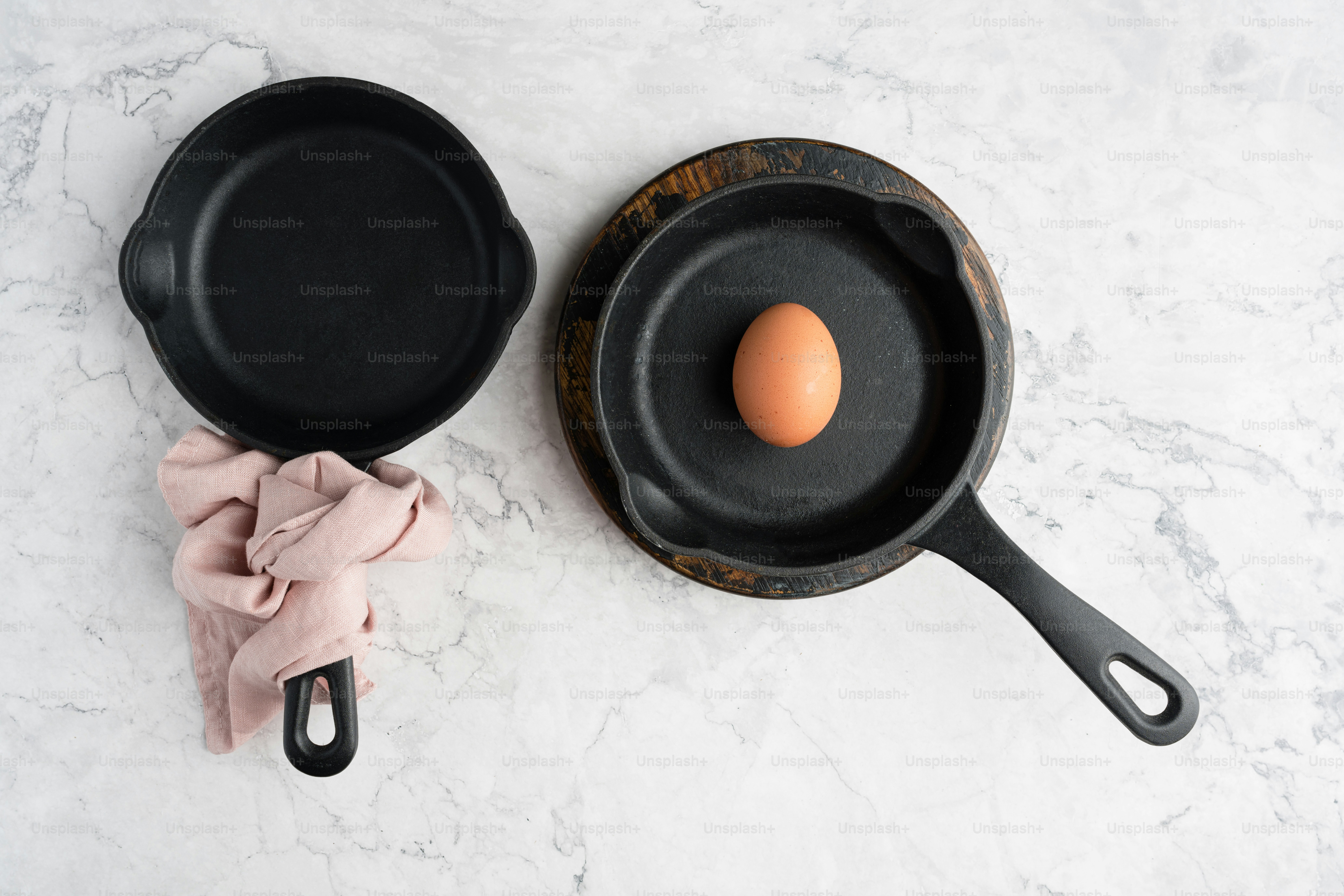 an egg in a frying pan next to a cast iron skillet