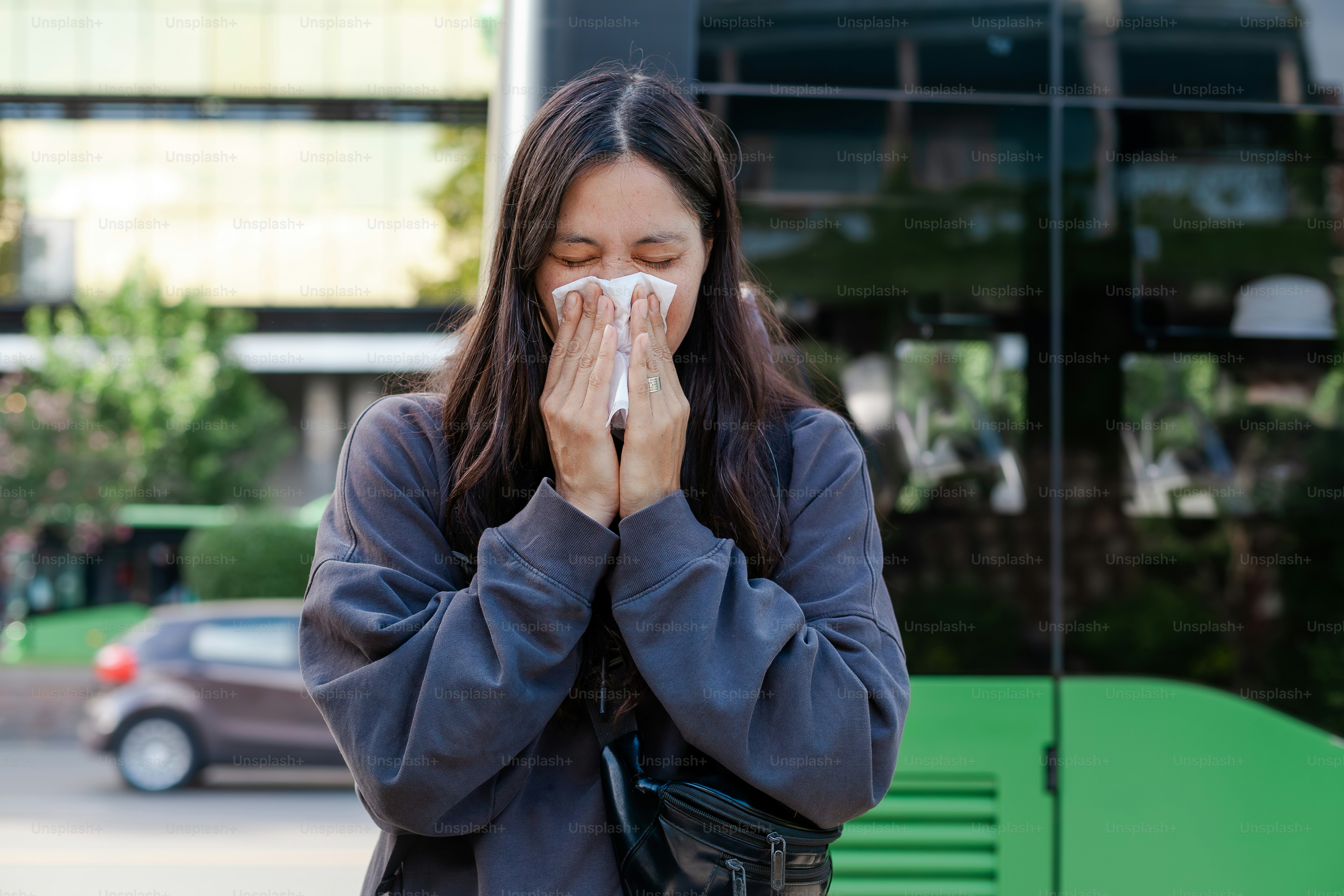a woman covers her mouth with a tissue