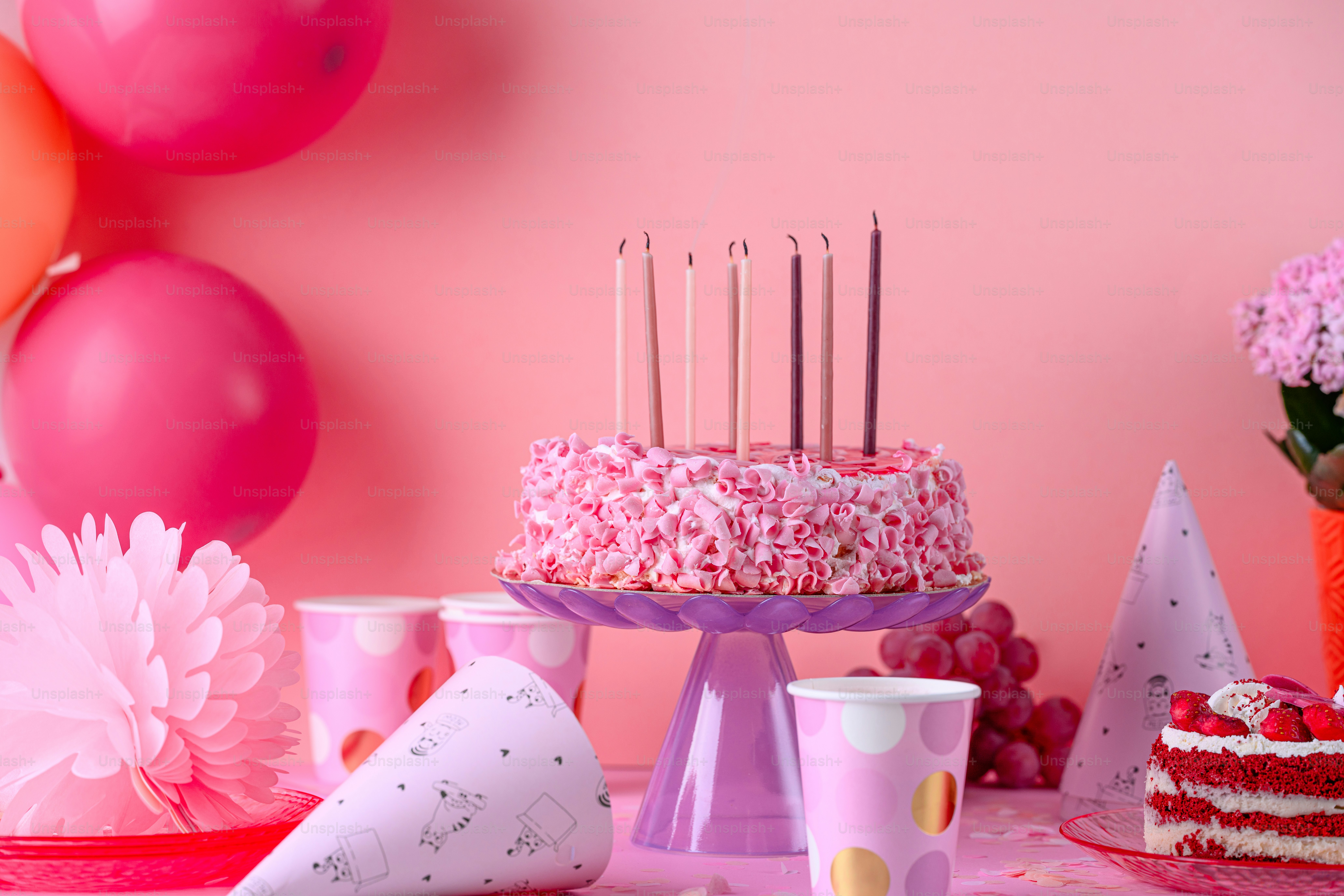 A table topped with a cake covered in pink frosting photo – Food Image ...