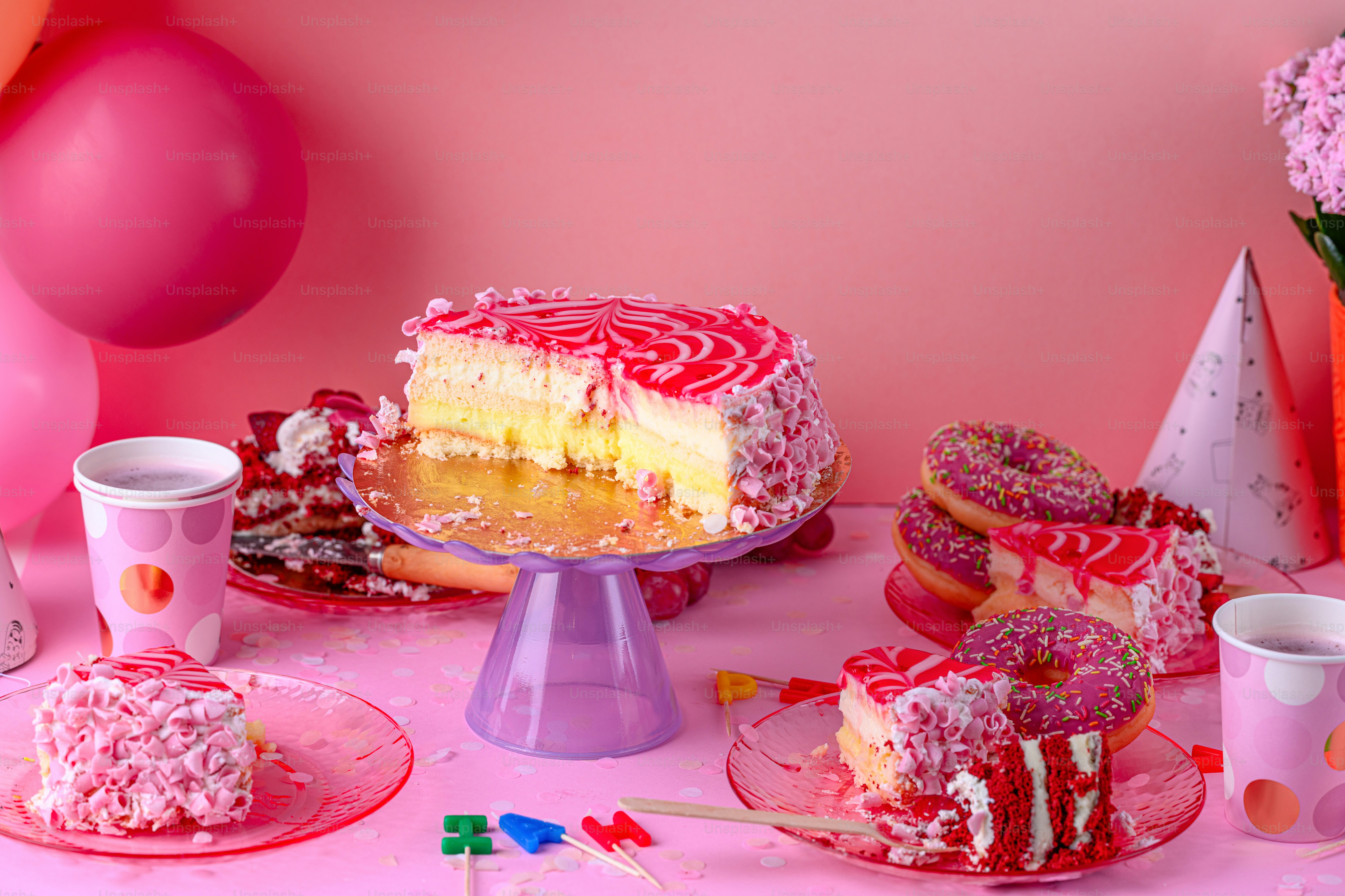 A table topped with a cake covered in pink frosting photo – Food Image ...