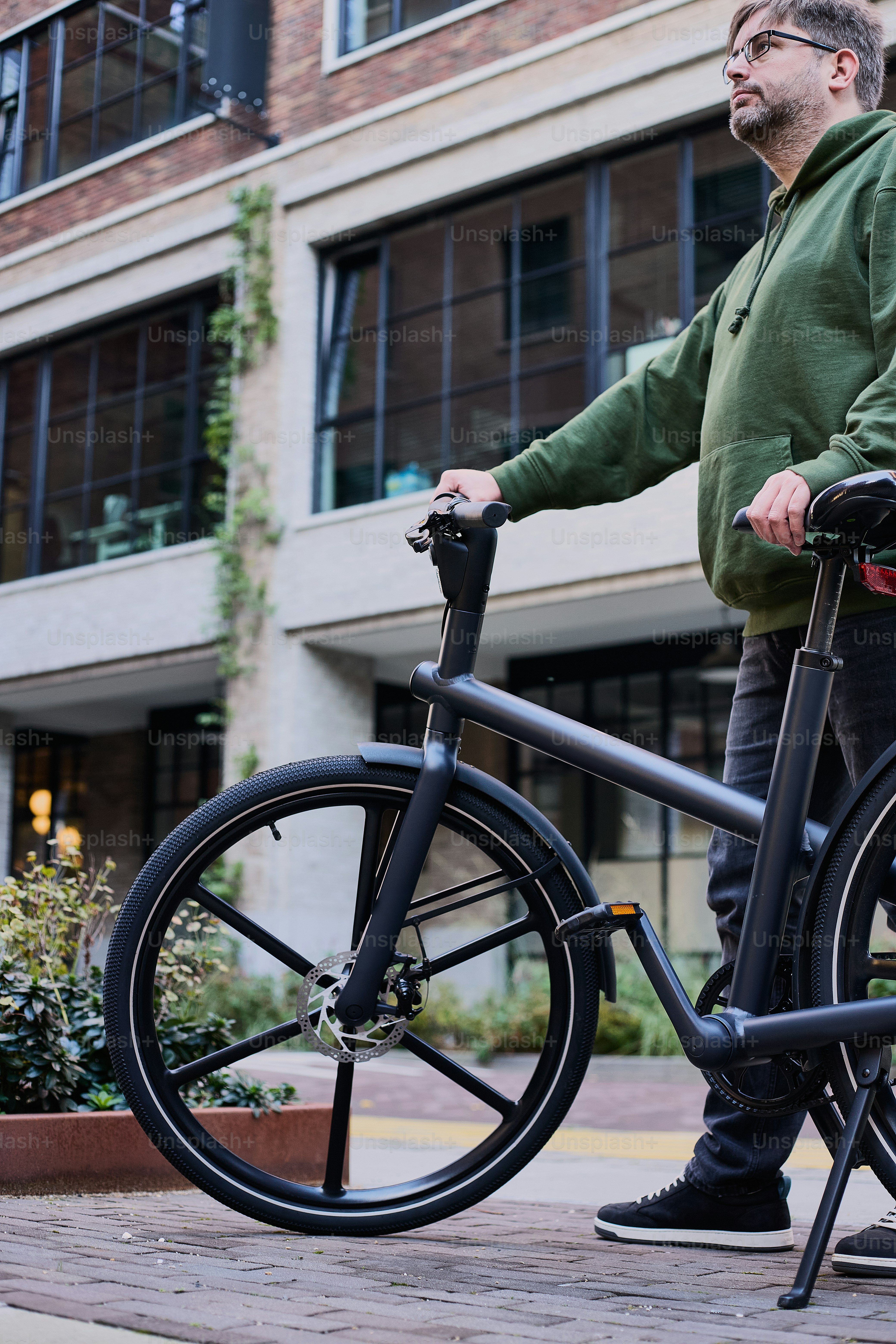 a man standing next to a bike on a sidewalk
