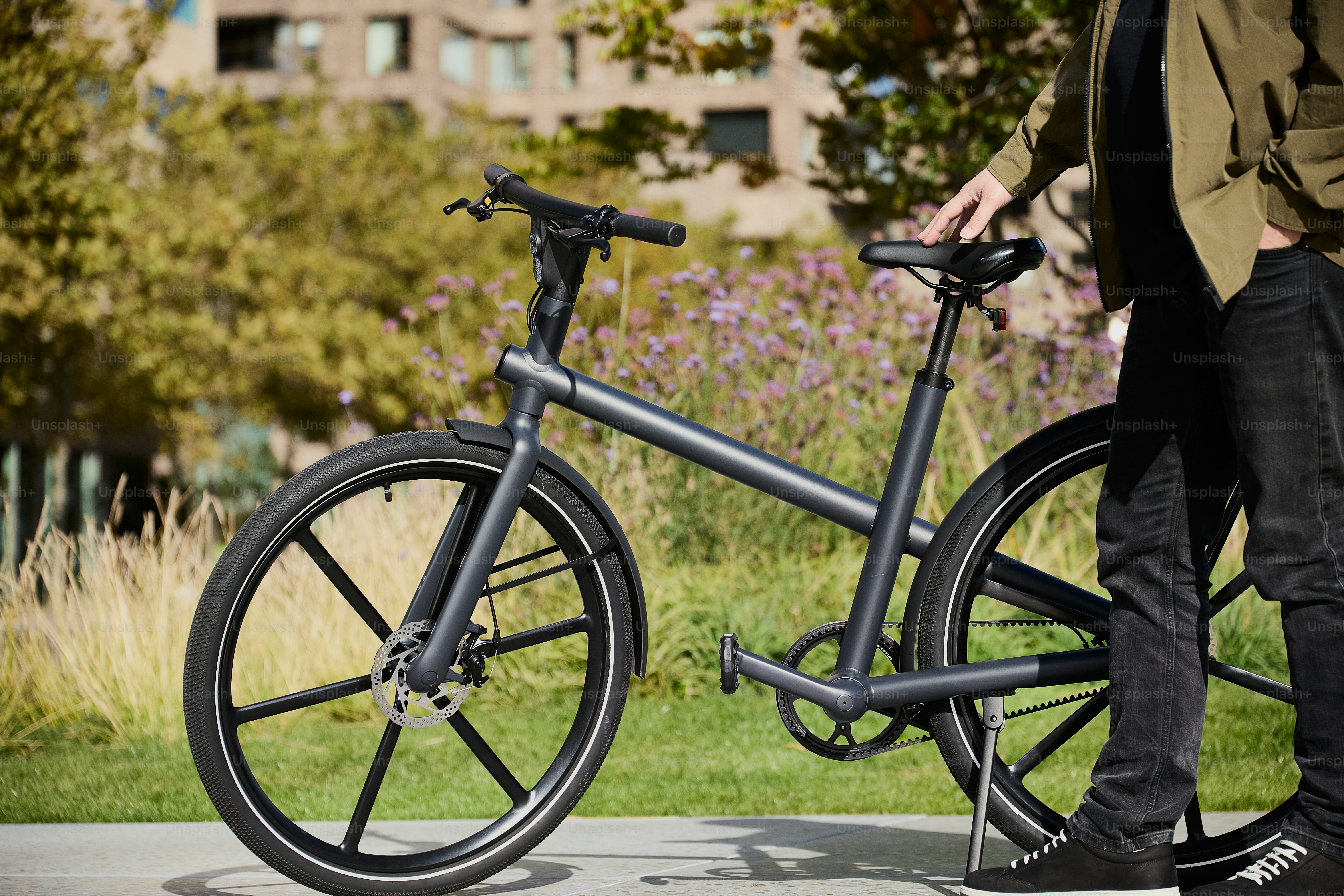 a person standing next to a bike on a sidewalk