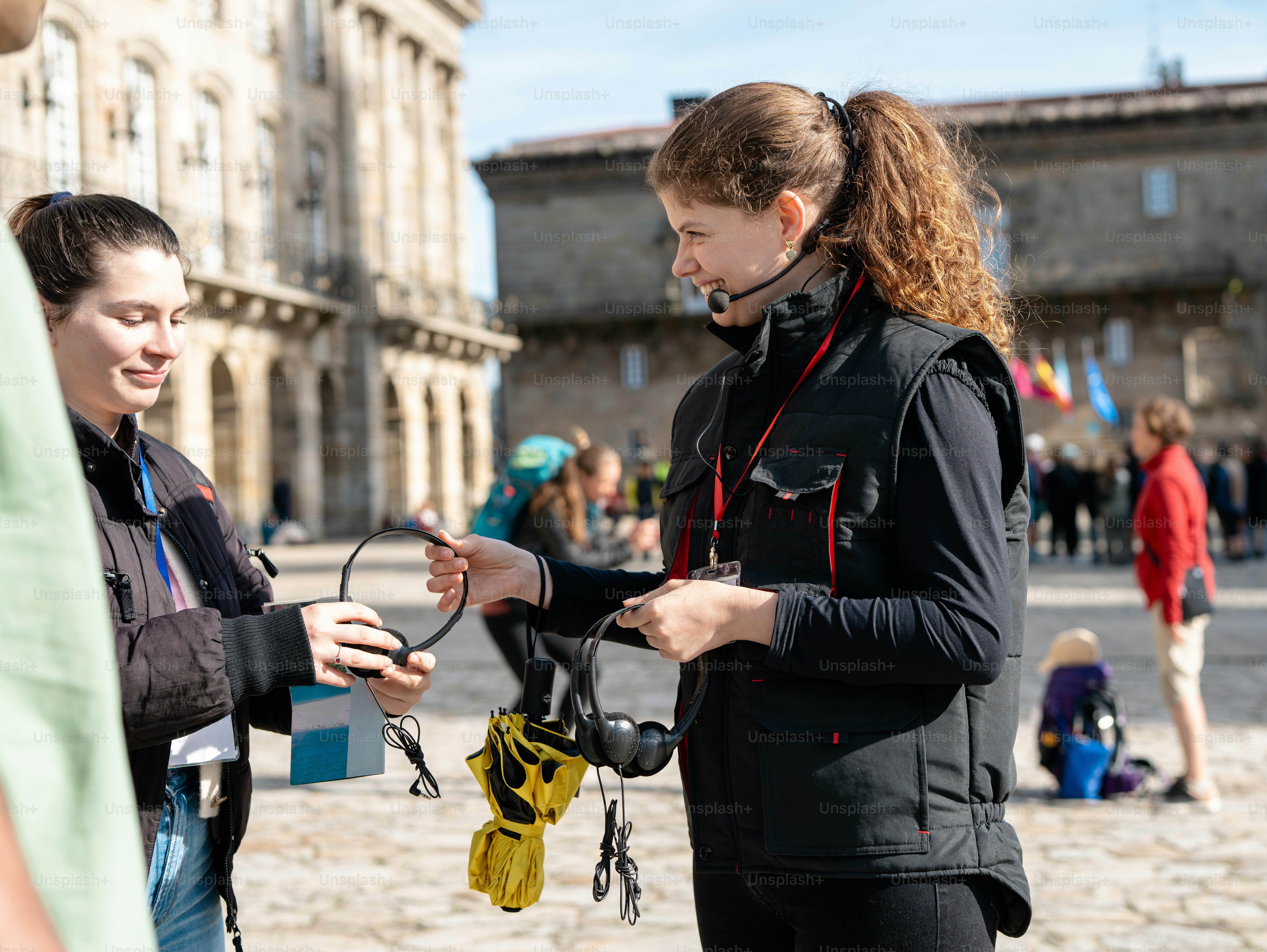 A woman holding a pair of scissors while standing next to another woman ...