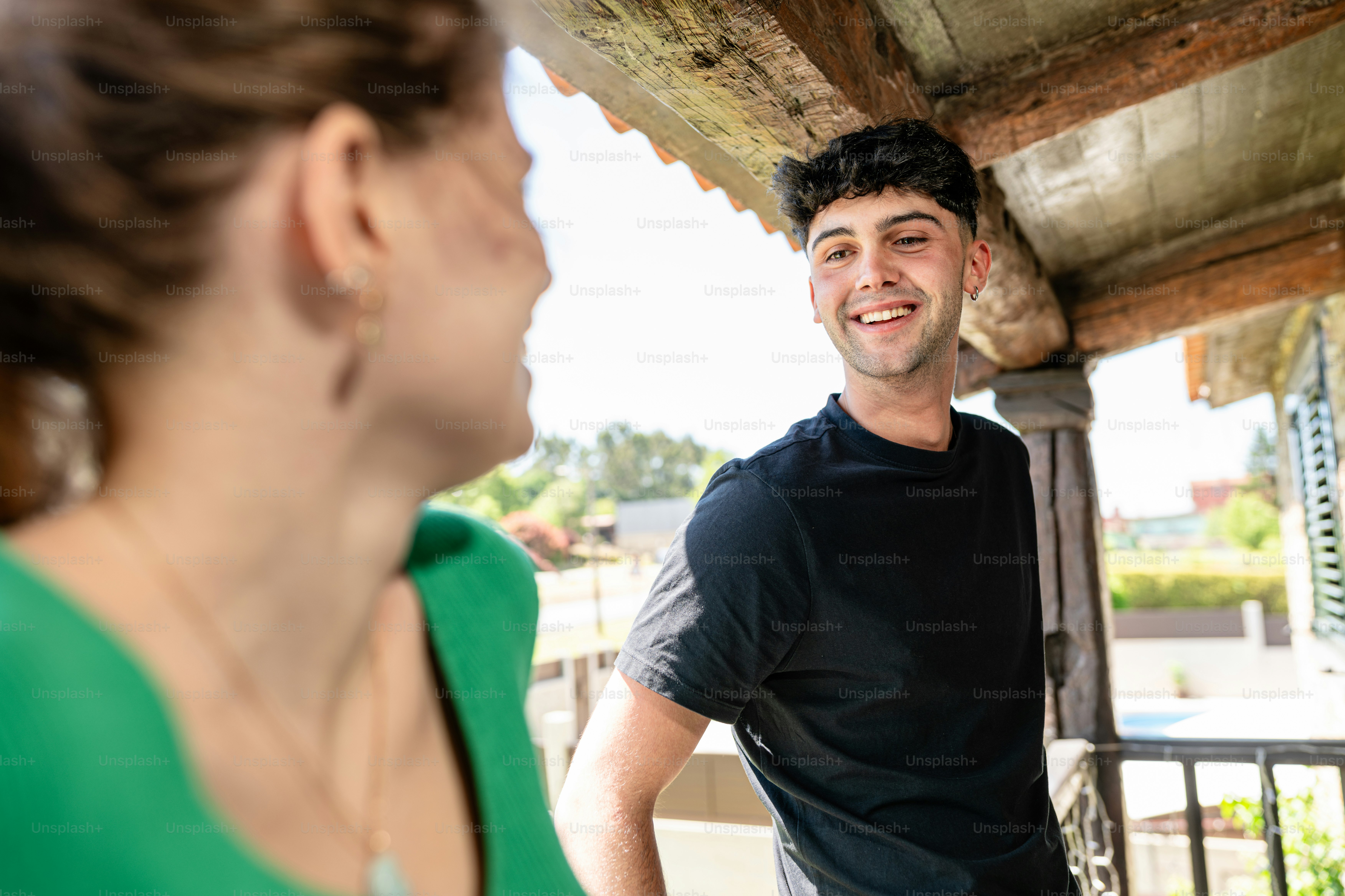 a man standing next to a woman on a porch