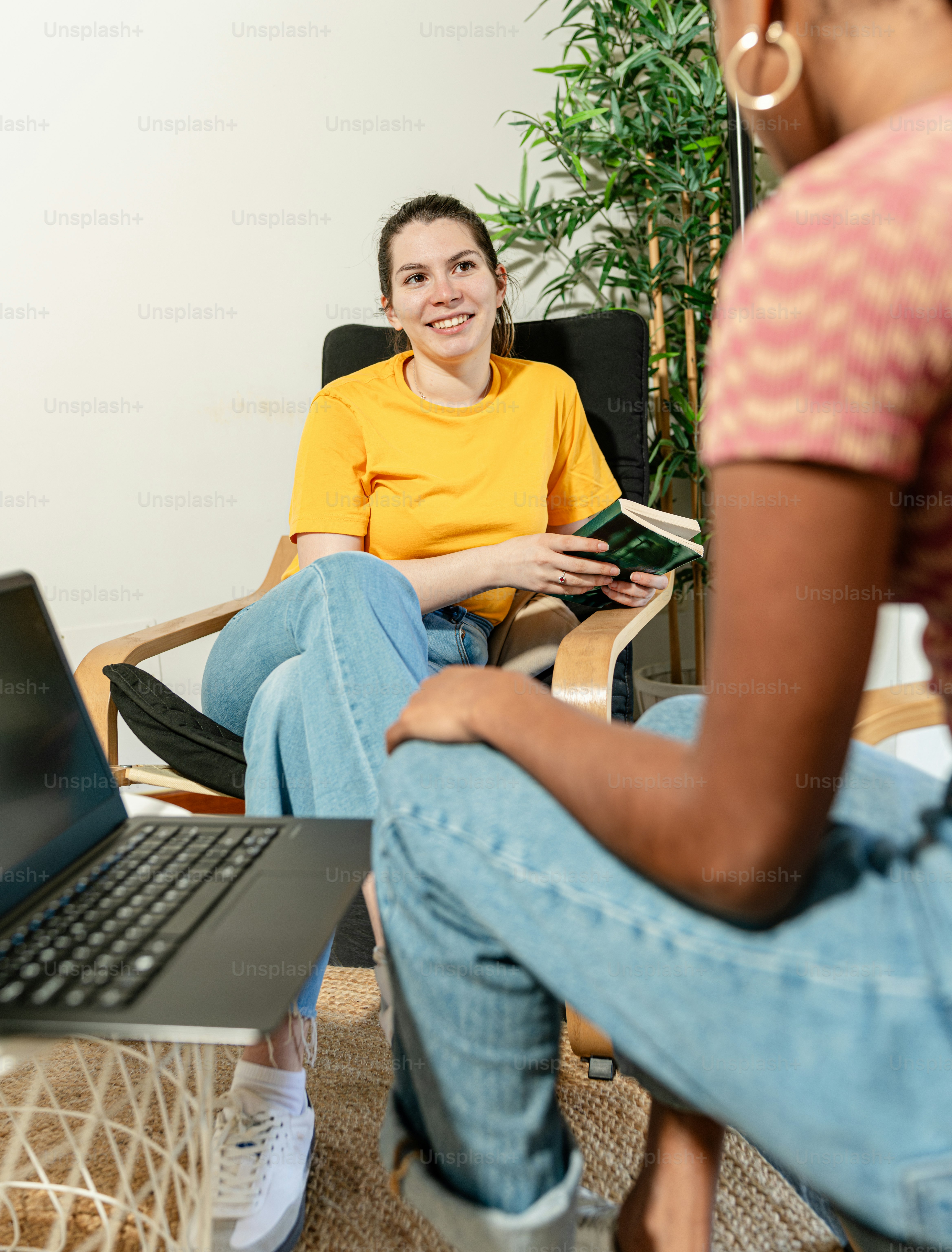 a woman sitting in a chair next to a laptop computer