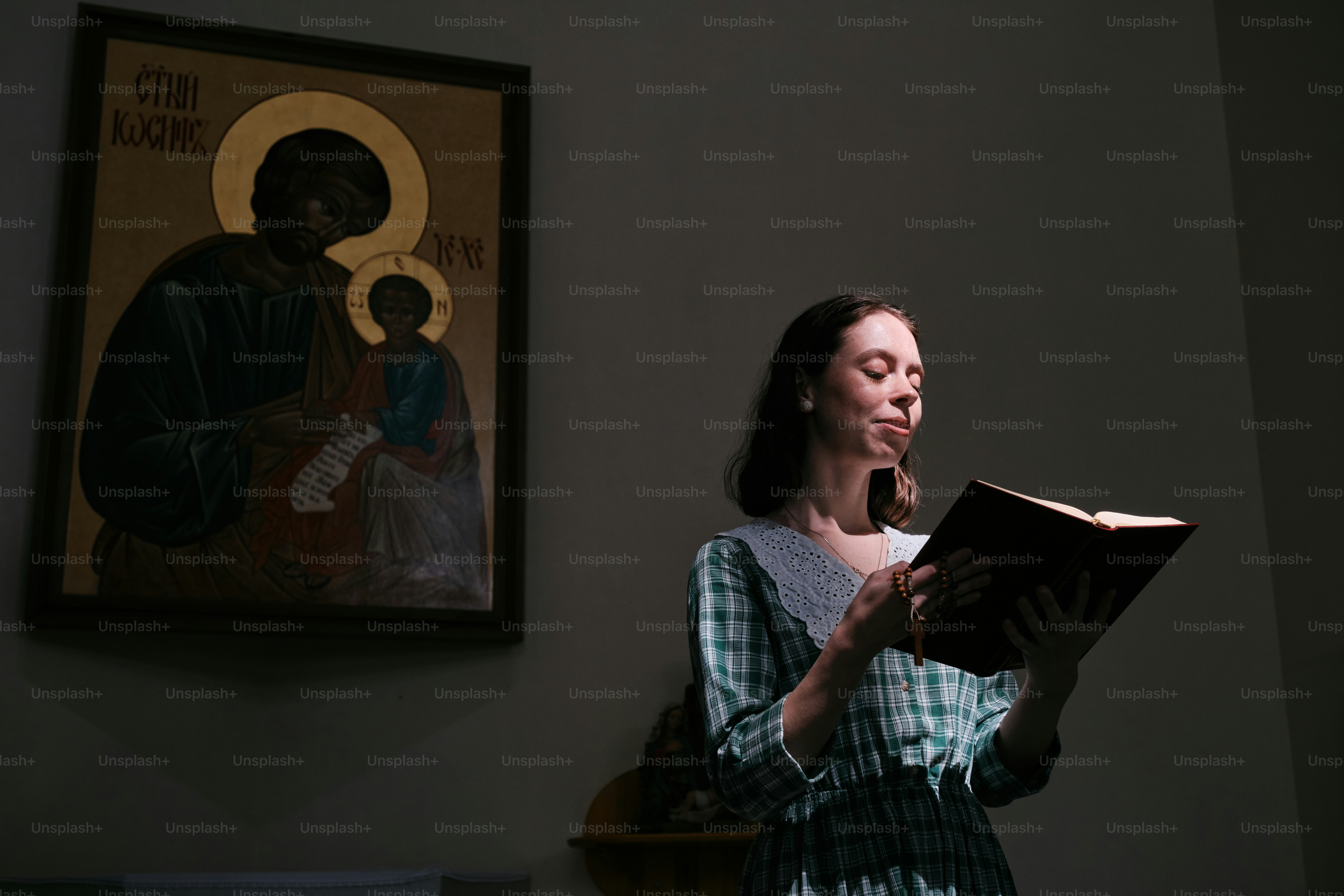a woman reading a book in a dark room