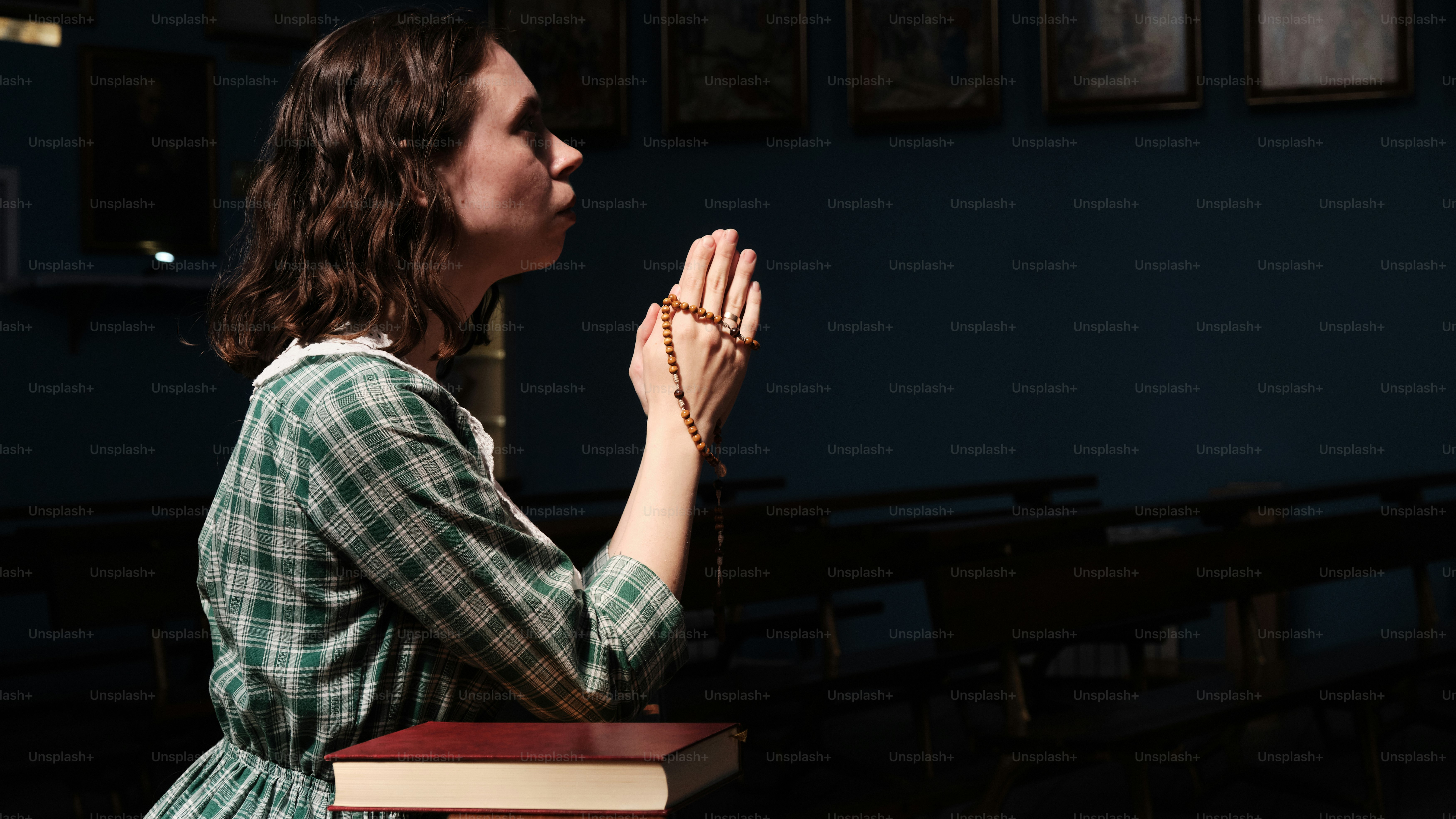 a woman in a green and white dress praying