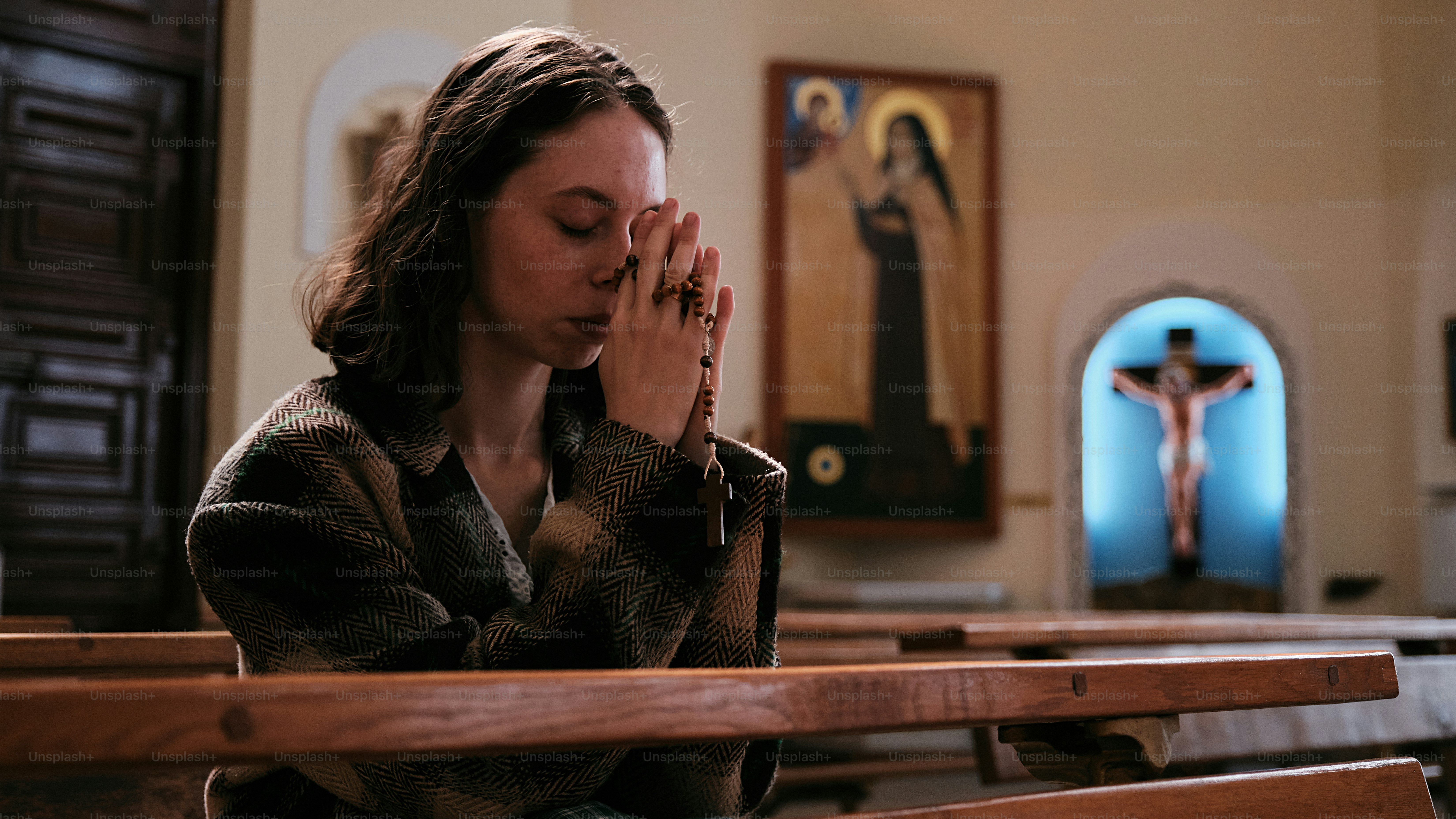 a woman kneeling down in a church praying