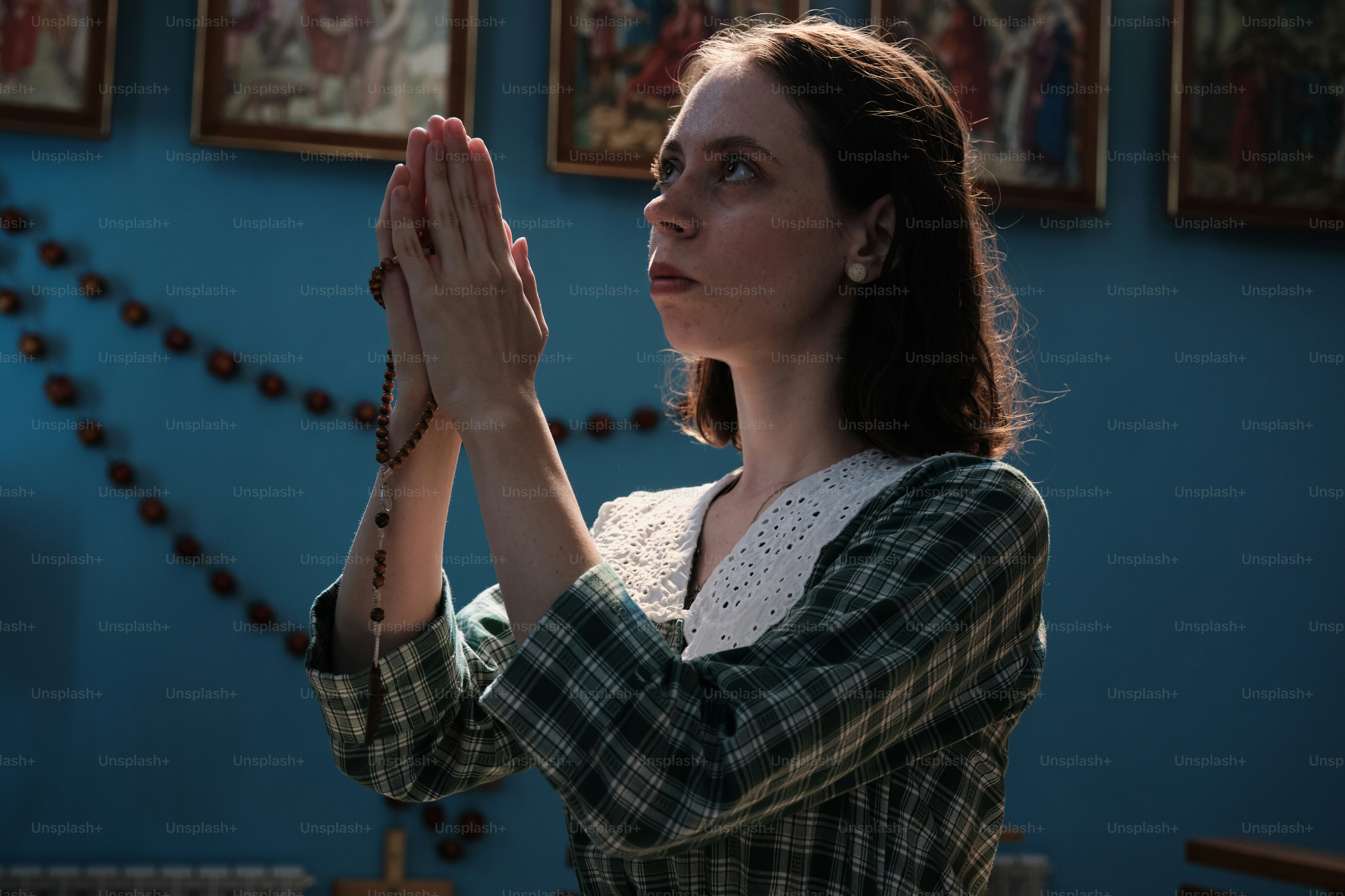 a woman in a green and white shirt holding her hands together