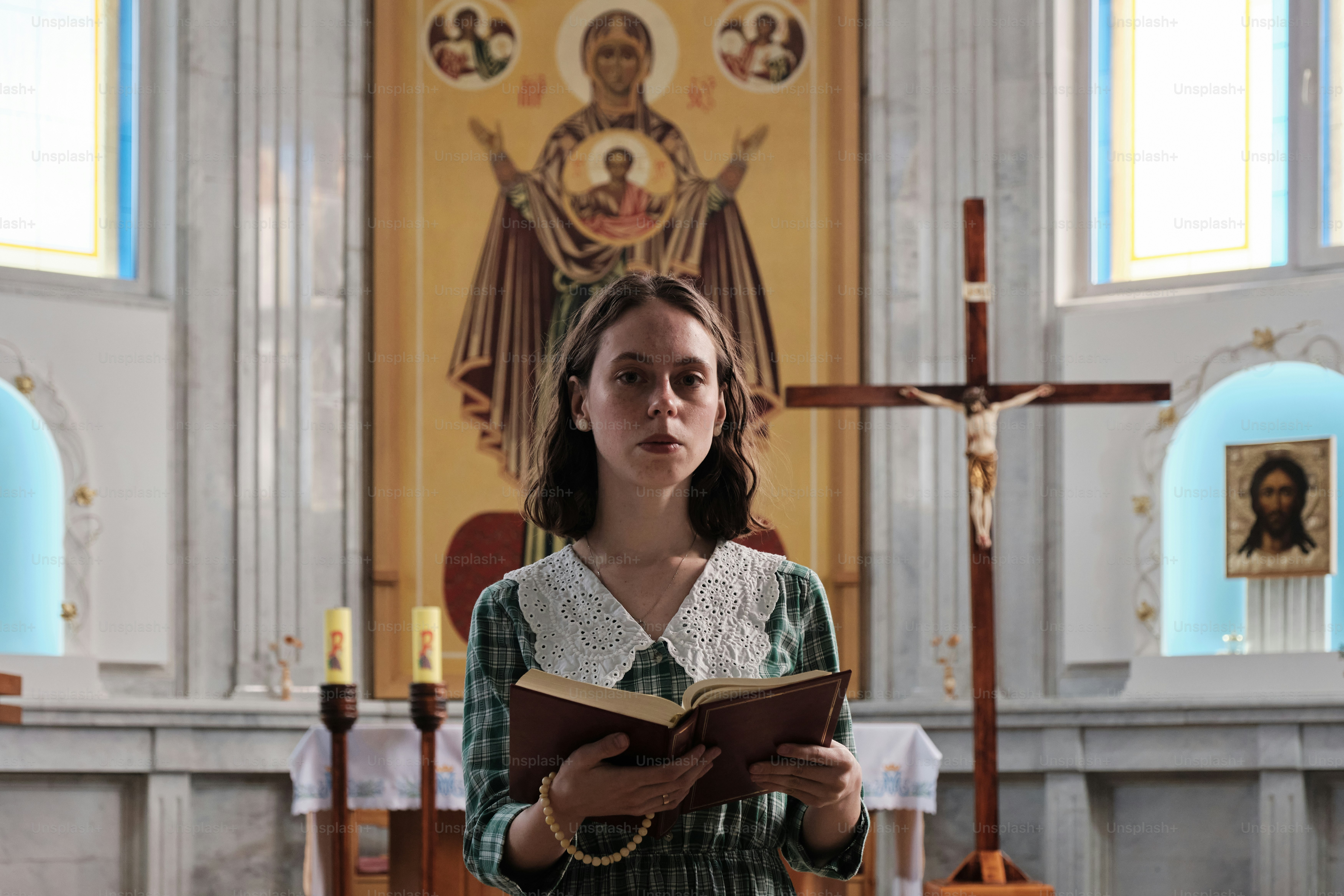 a woman standing in a church holding a book