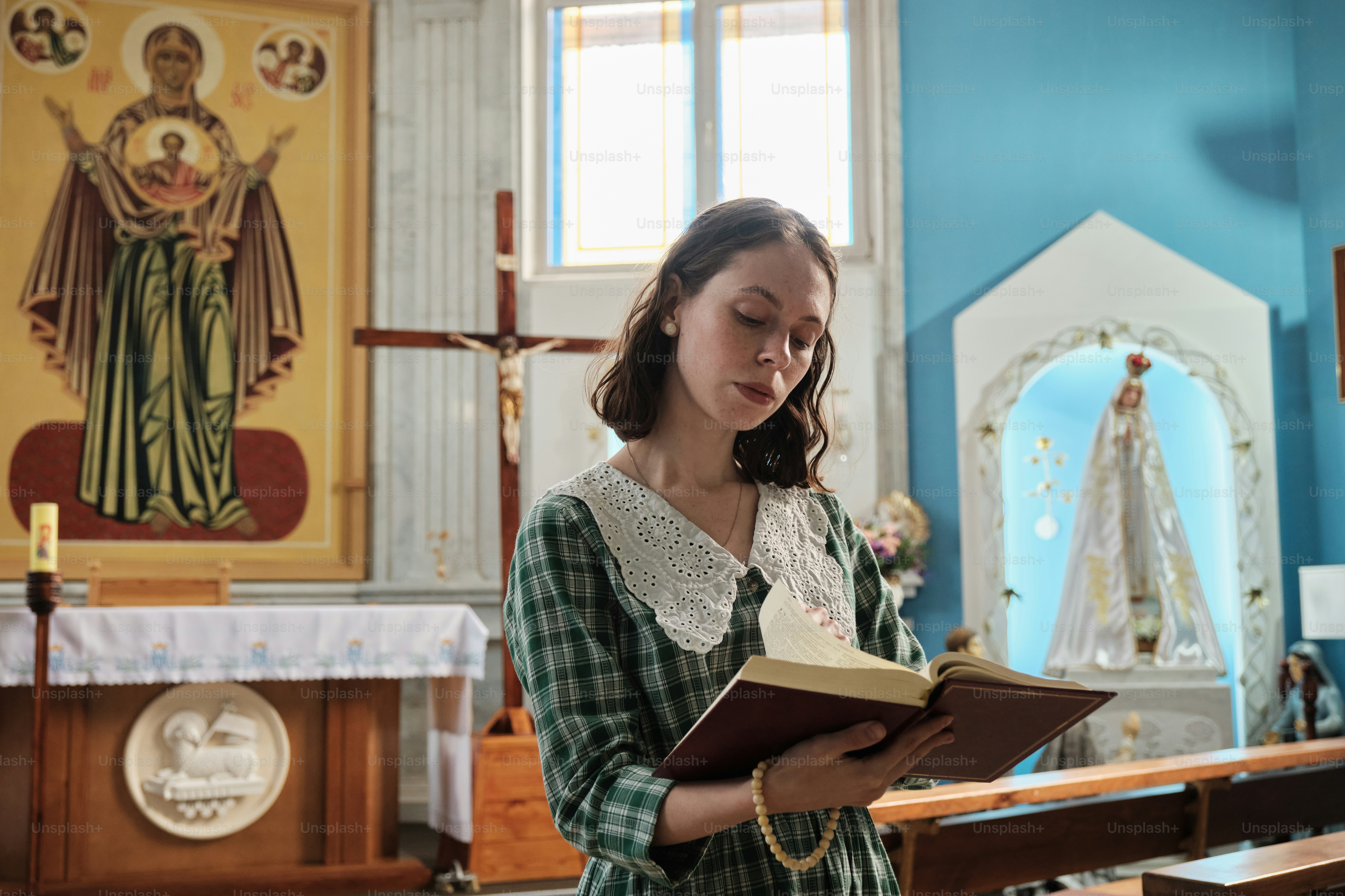 a woman standing in a church holding a book