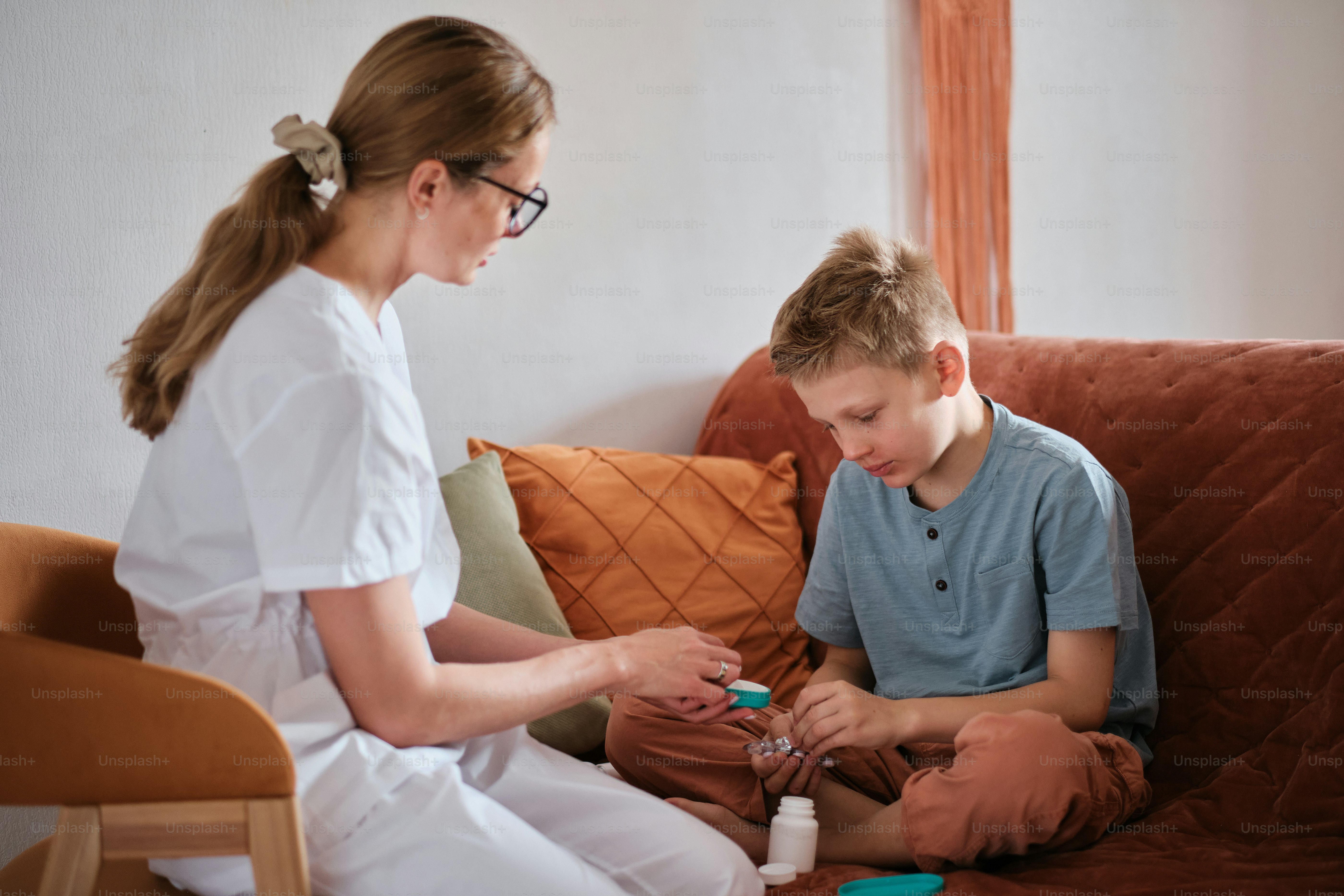 a woman sitting next to a boy on a couch