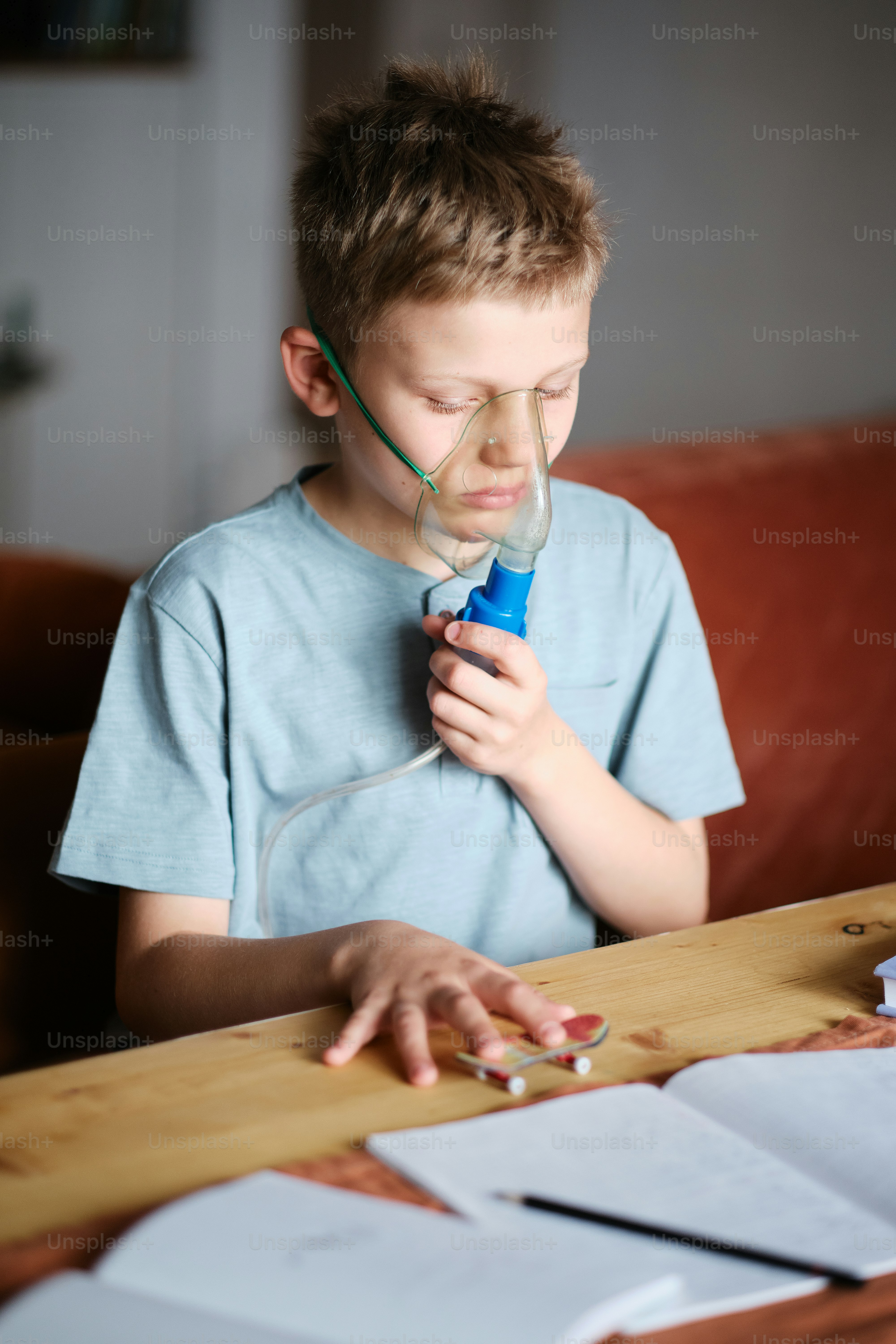 a young boy is using a blow dryer on a table