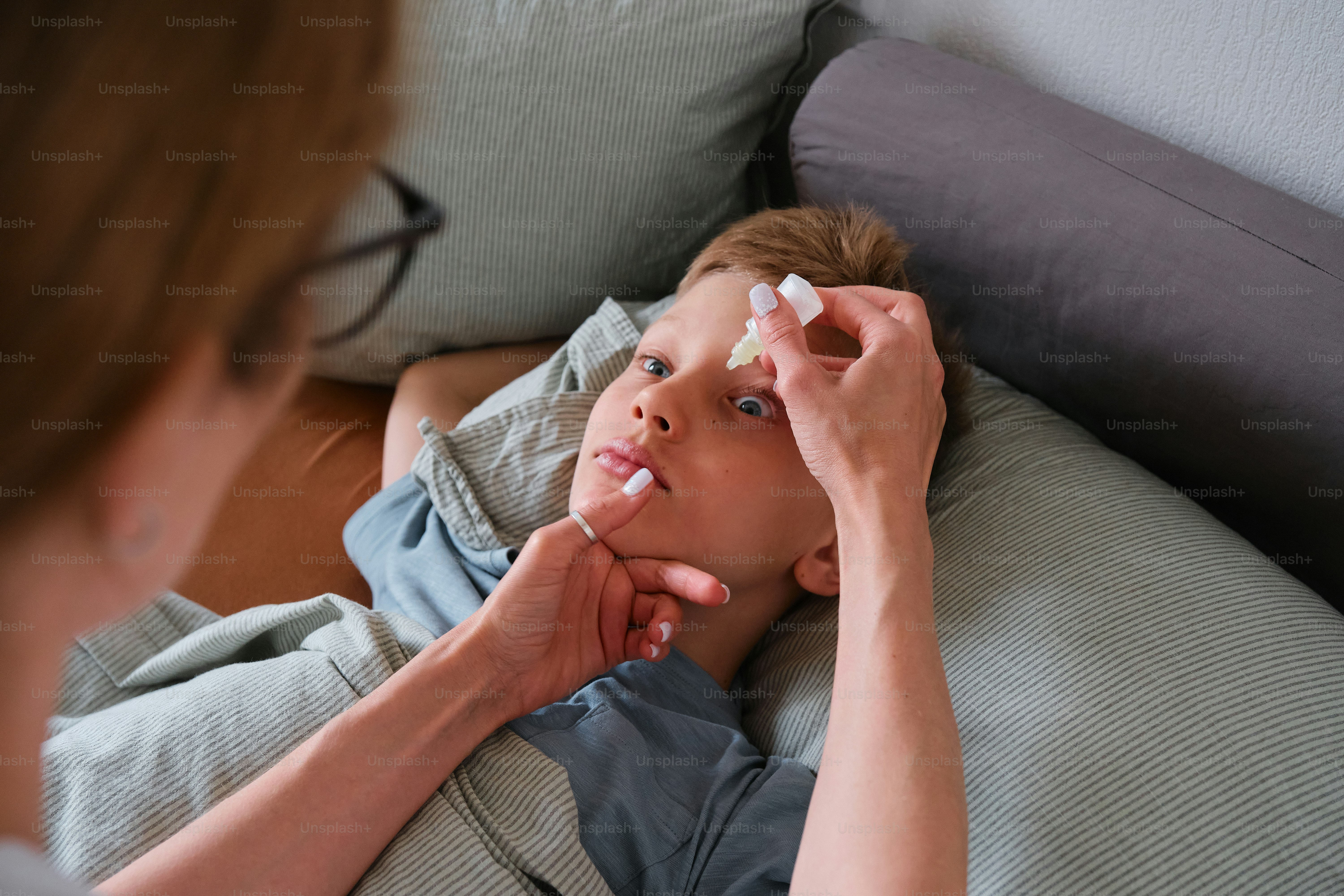 a woman laying on a bed with a toothbrush in her mouth