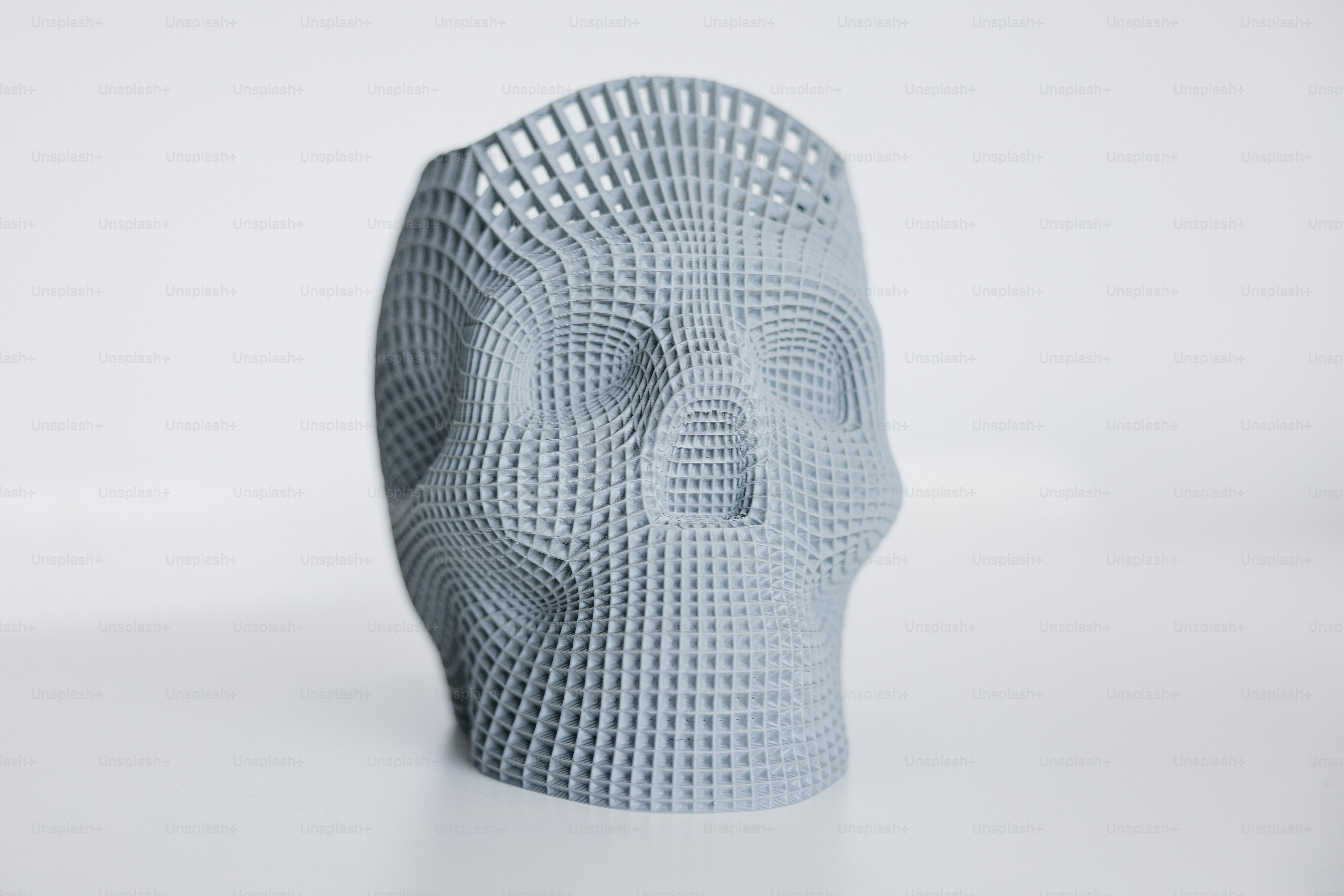 une sculpture blanche d’une tête humaine sur une surface blanche