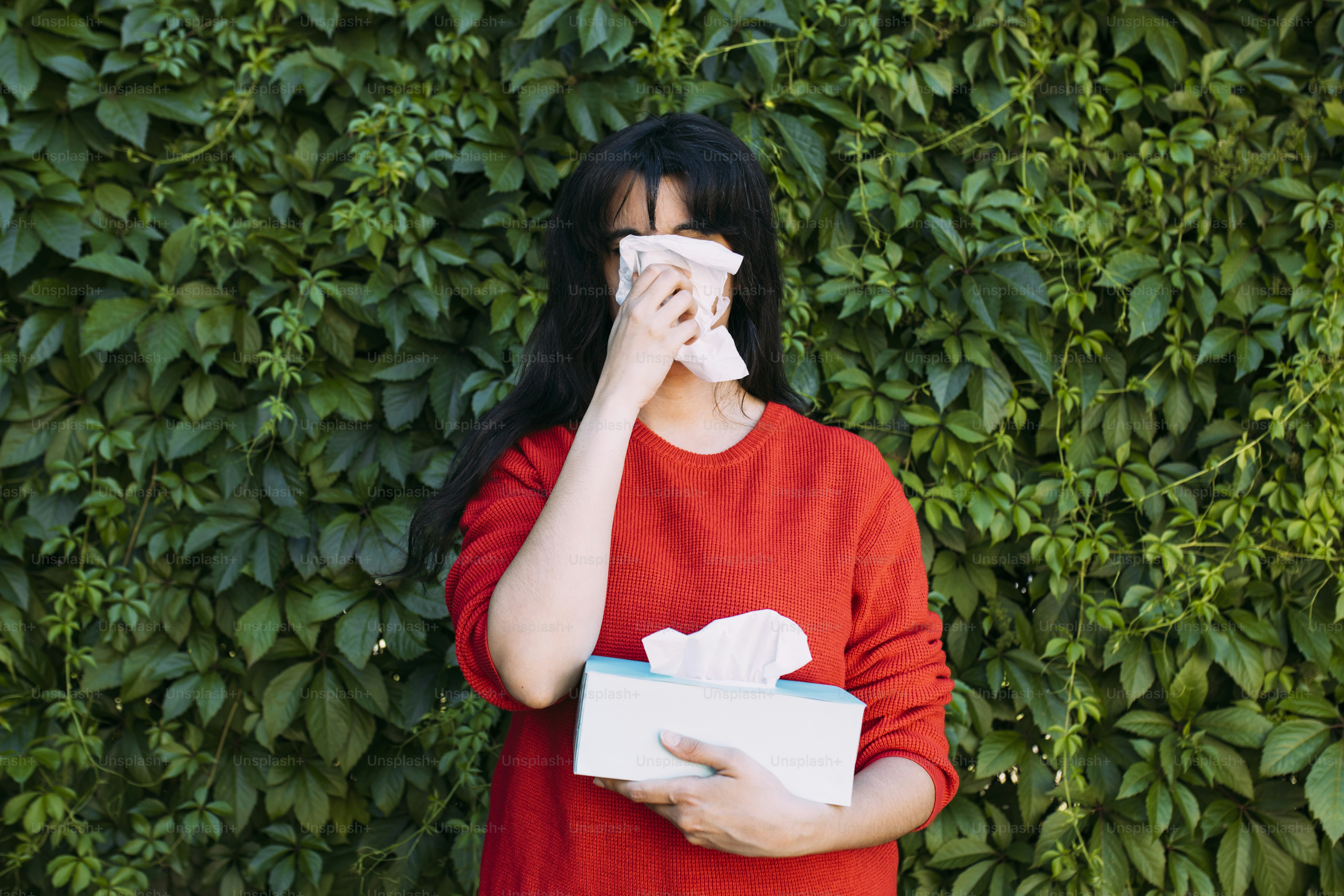 Une femme se couvre le visage avec un mouchoir en papier
