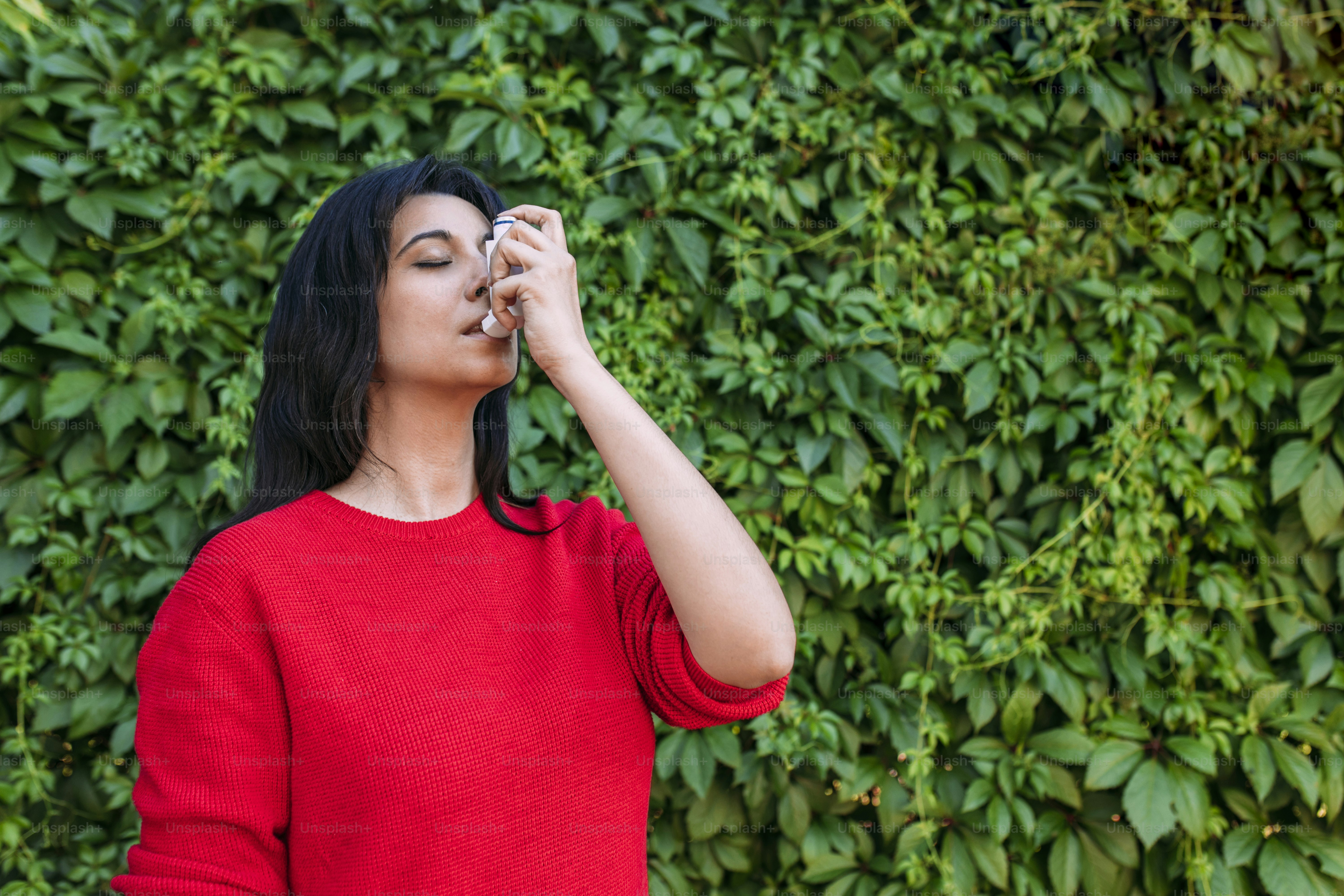 a woman standing in front of a green wall