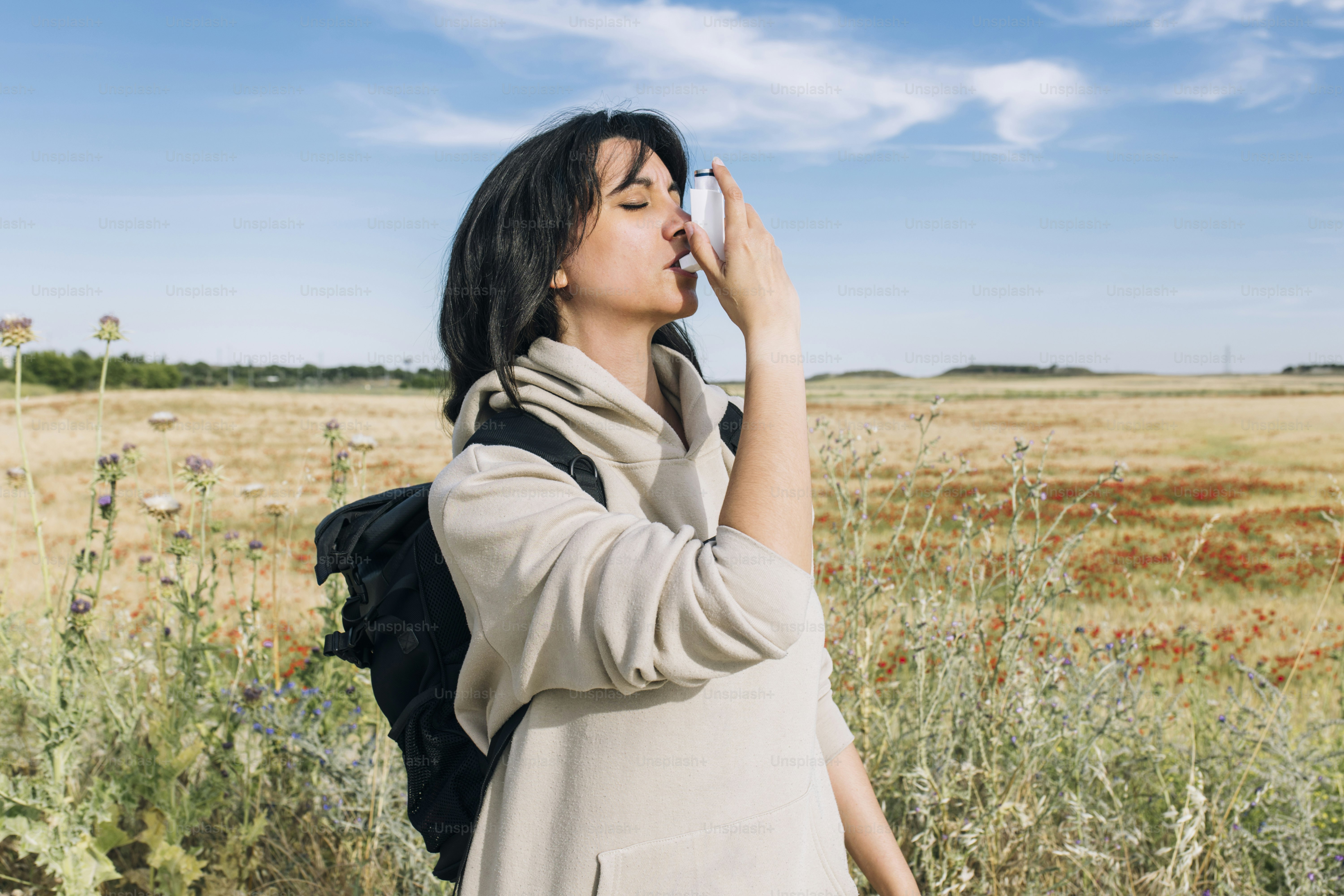 a woman standing in a field with her eyes closed