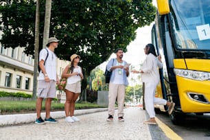 a group of people standing next to a yellow bus