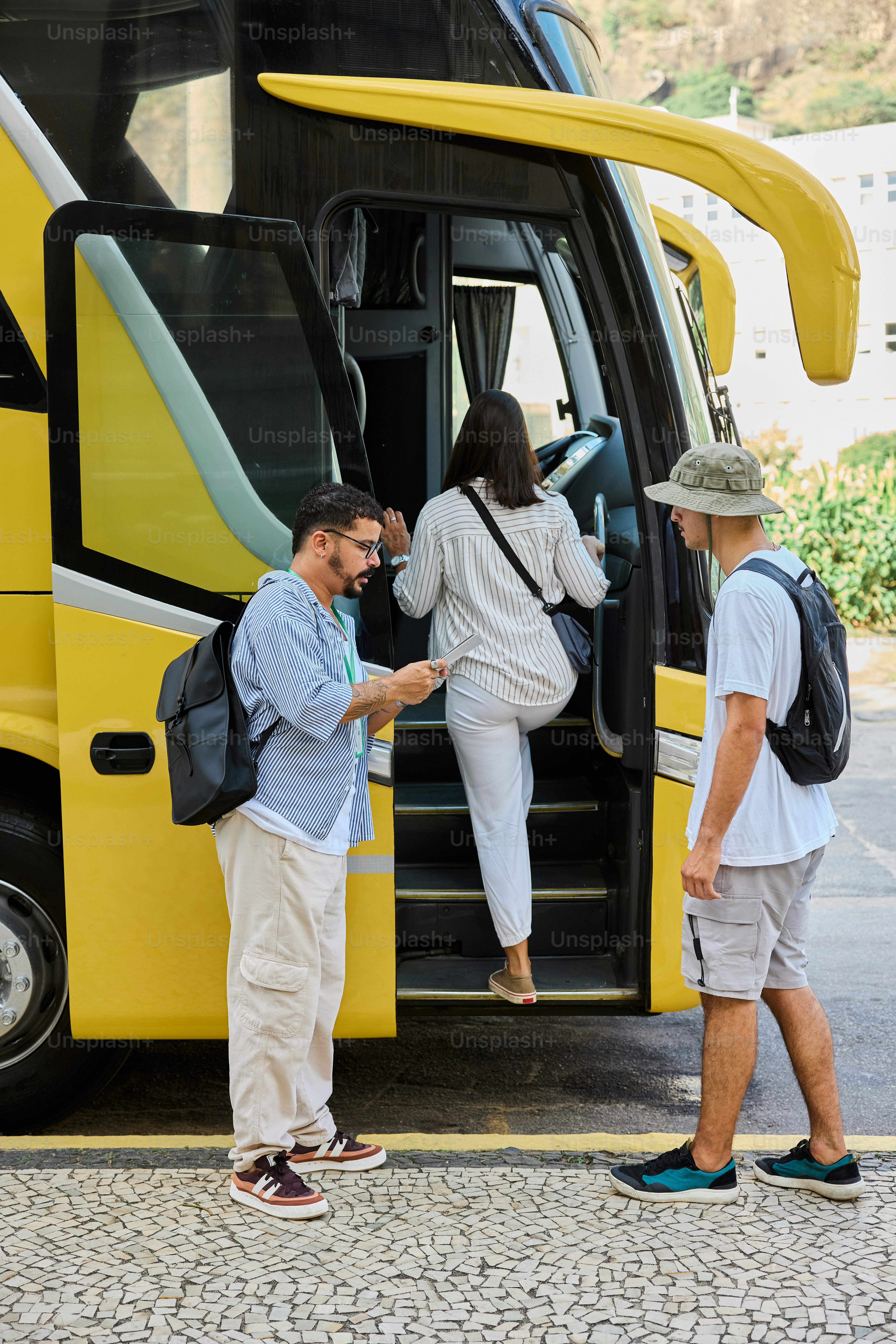 a man and a woman getting out of a yellow bus