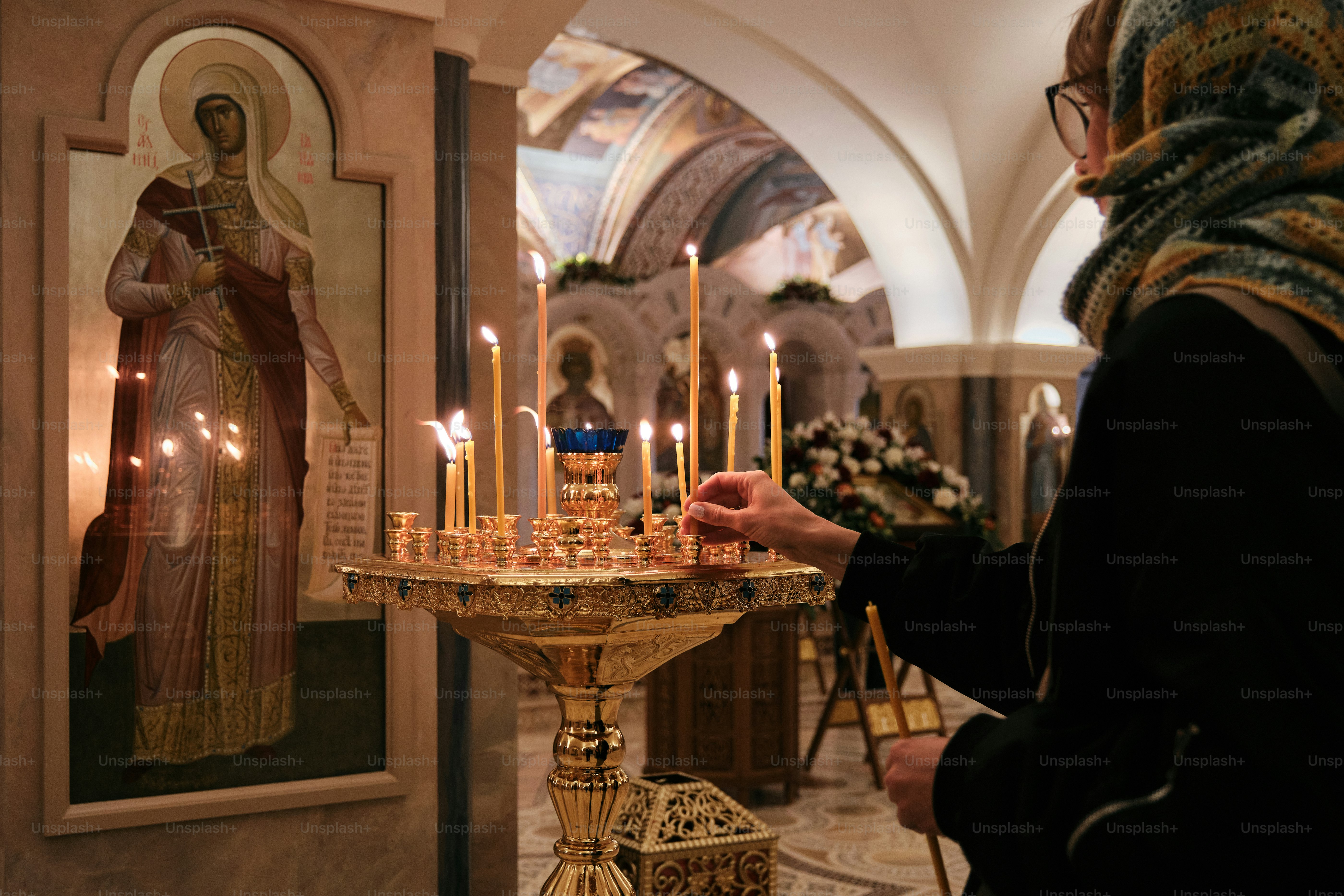 uma mulher está acendendo velas em uma igreja
