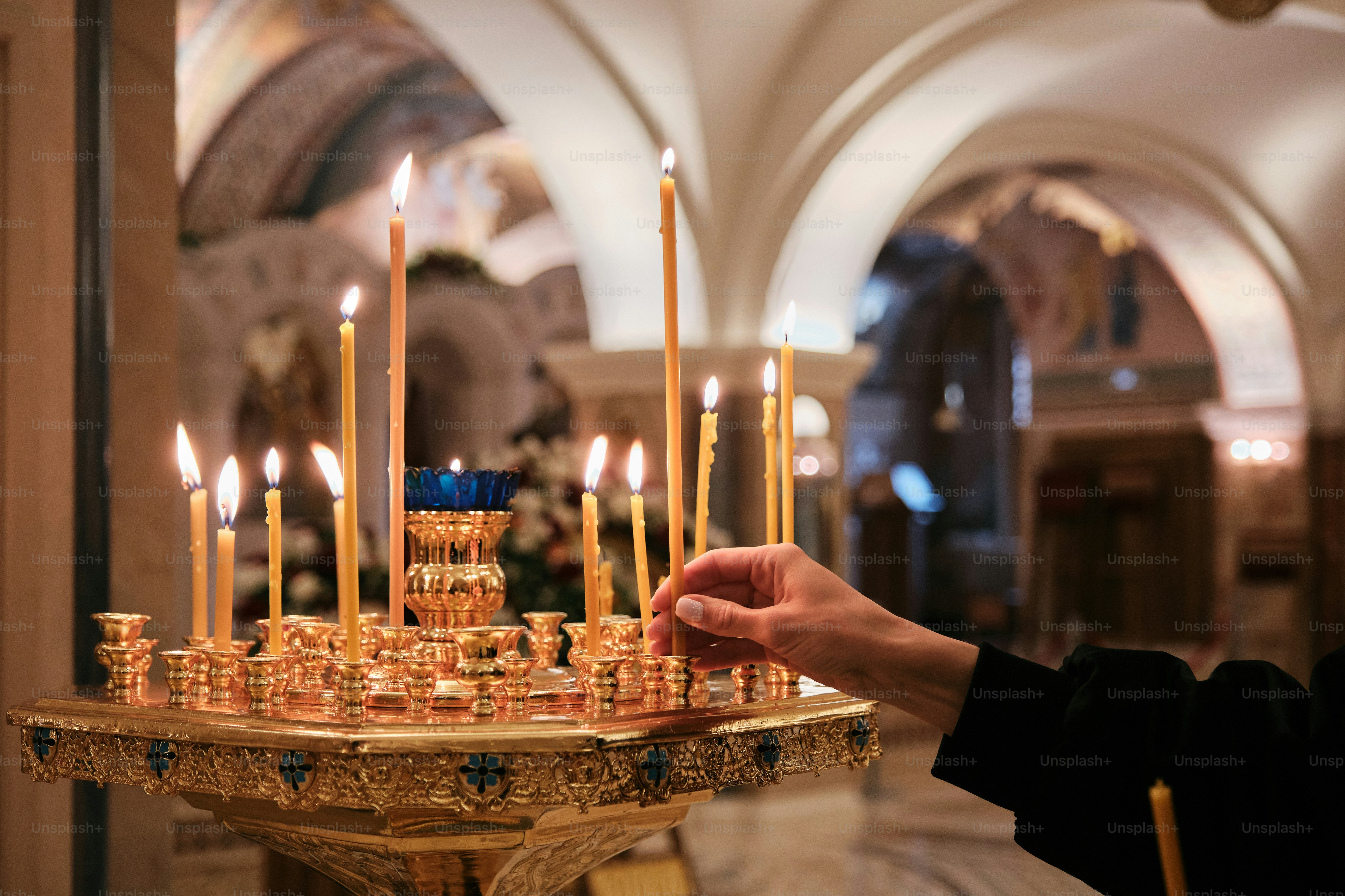 a person holding a candle in front of a large cake