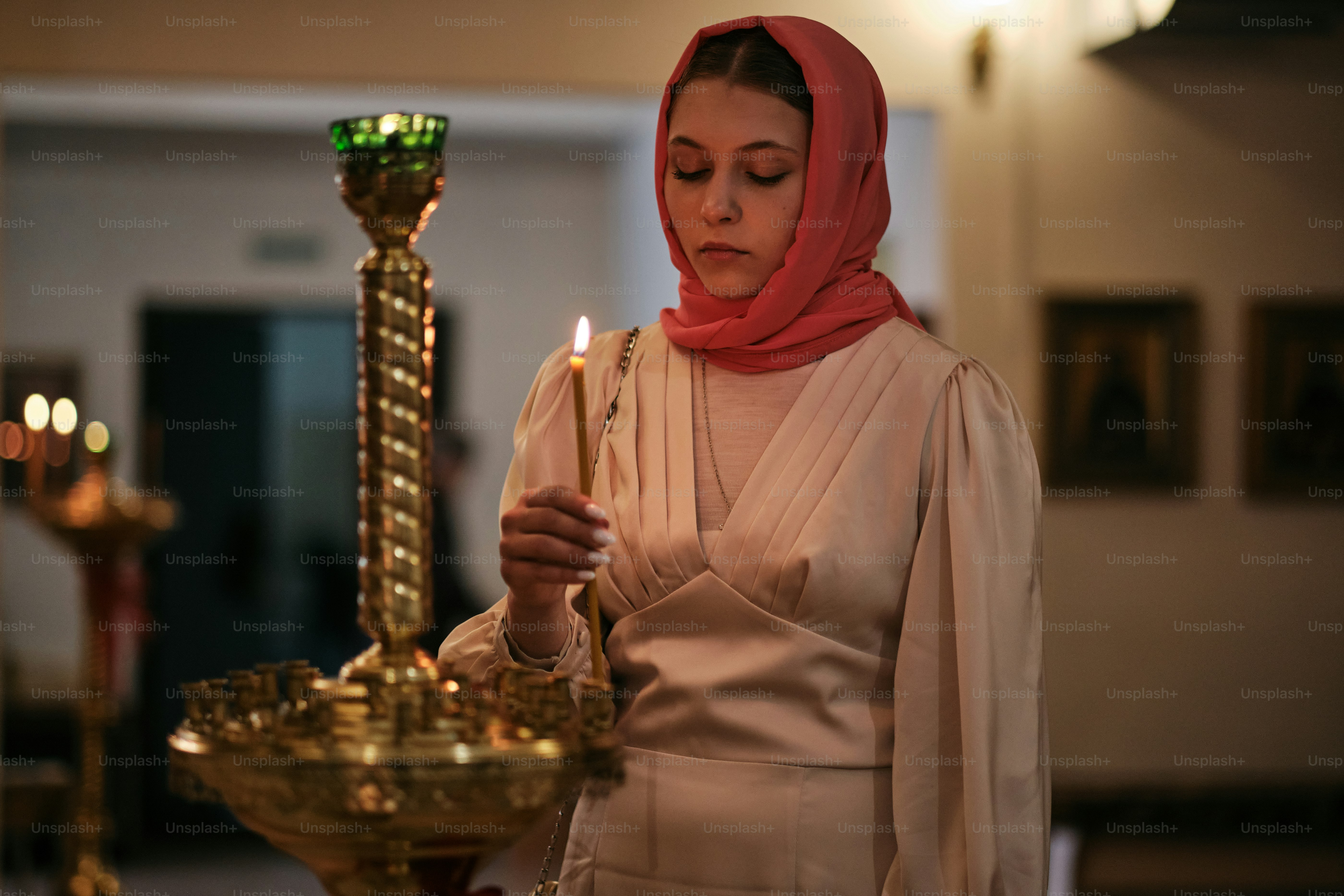 Seorang wanita berjilbab menyalakan lilin