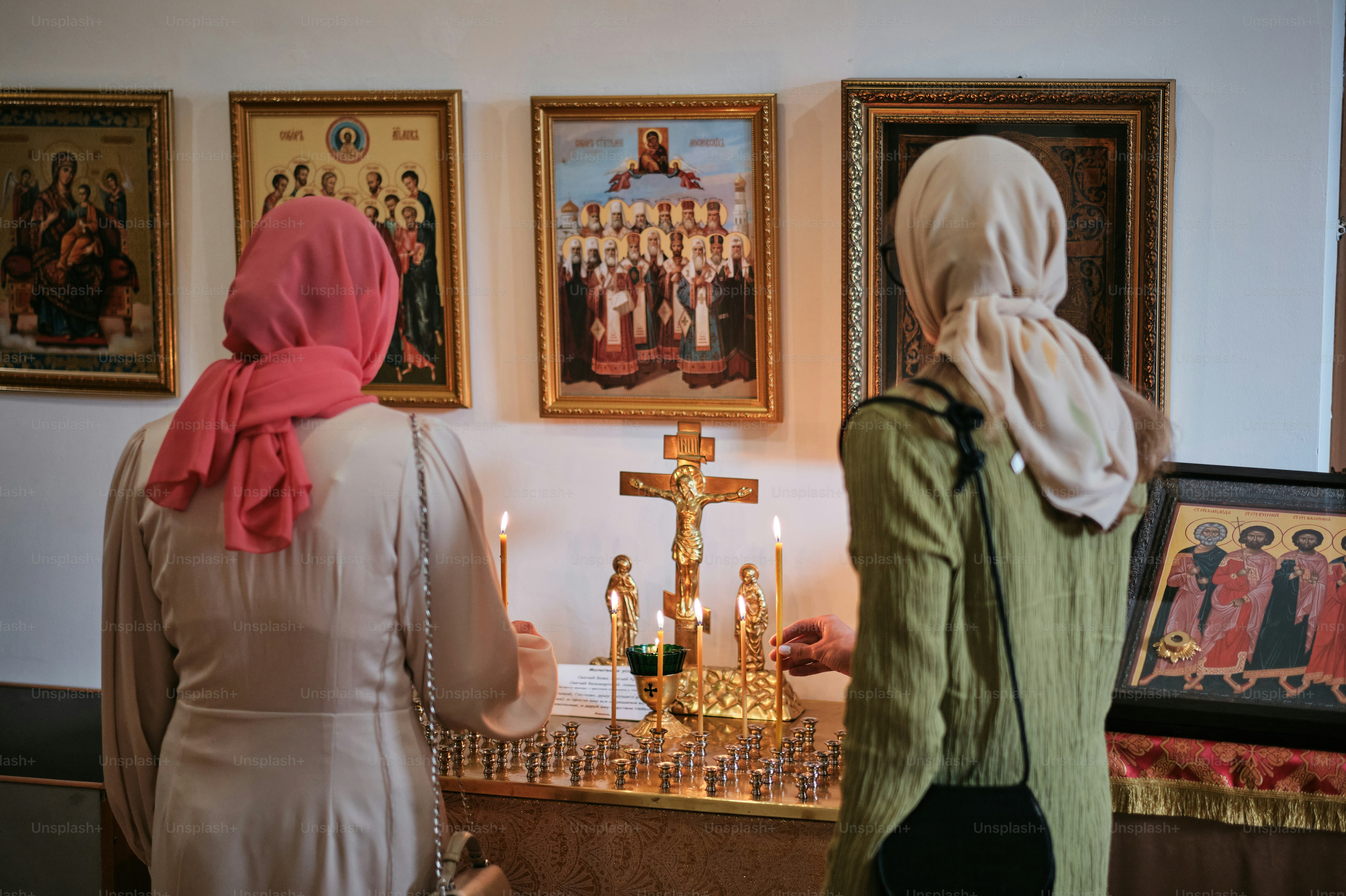 um casal de mulheres em pé na frente de uma cruz
