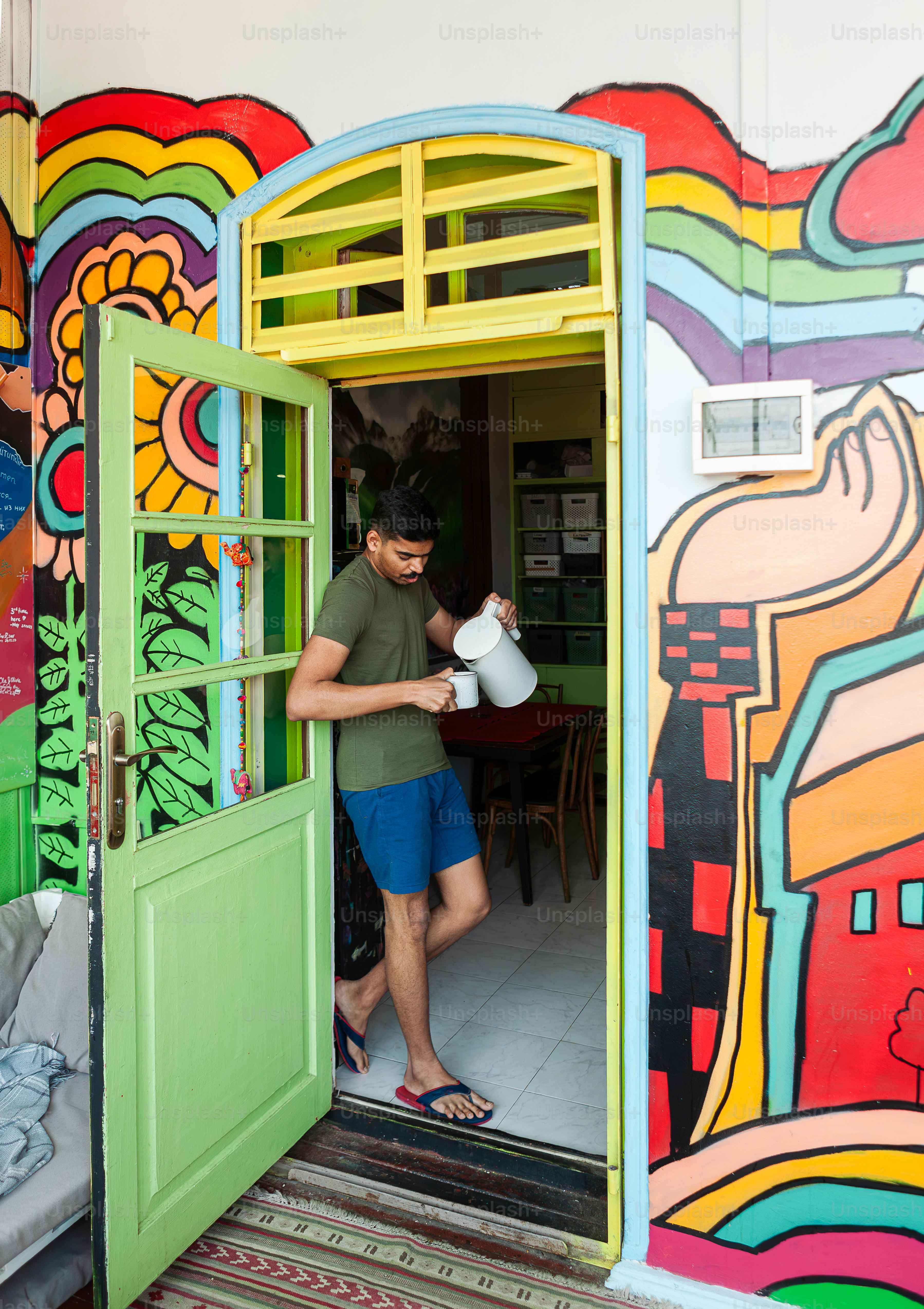 a man standing in a doorway with a jug in his hand