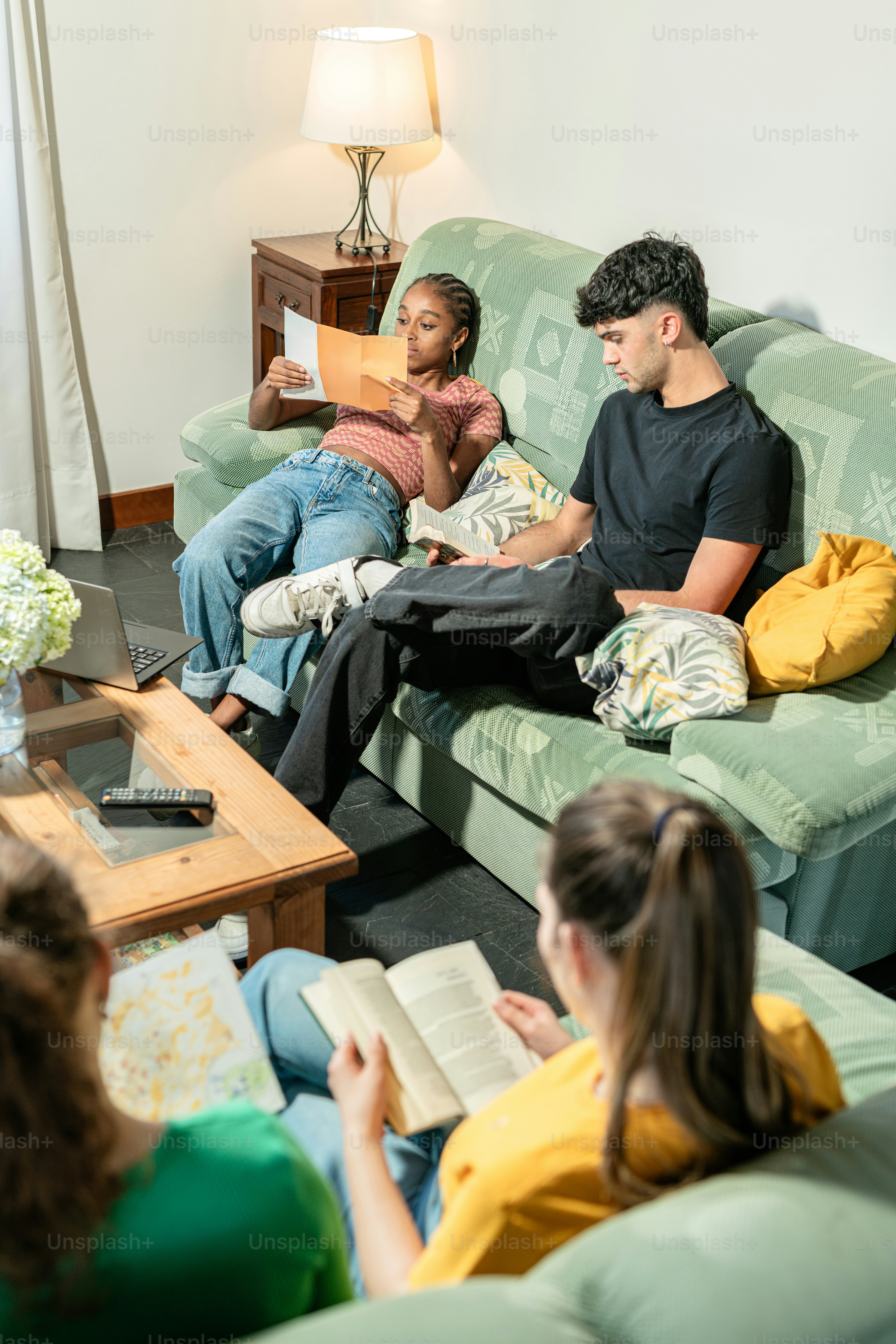 A group of people sitting on a couch in a living room photo – Education ...