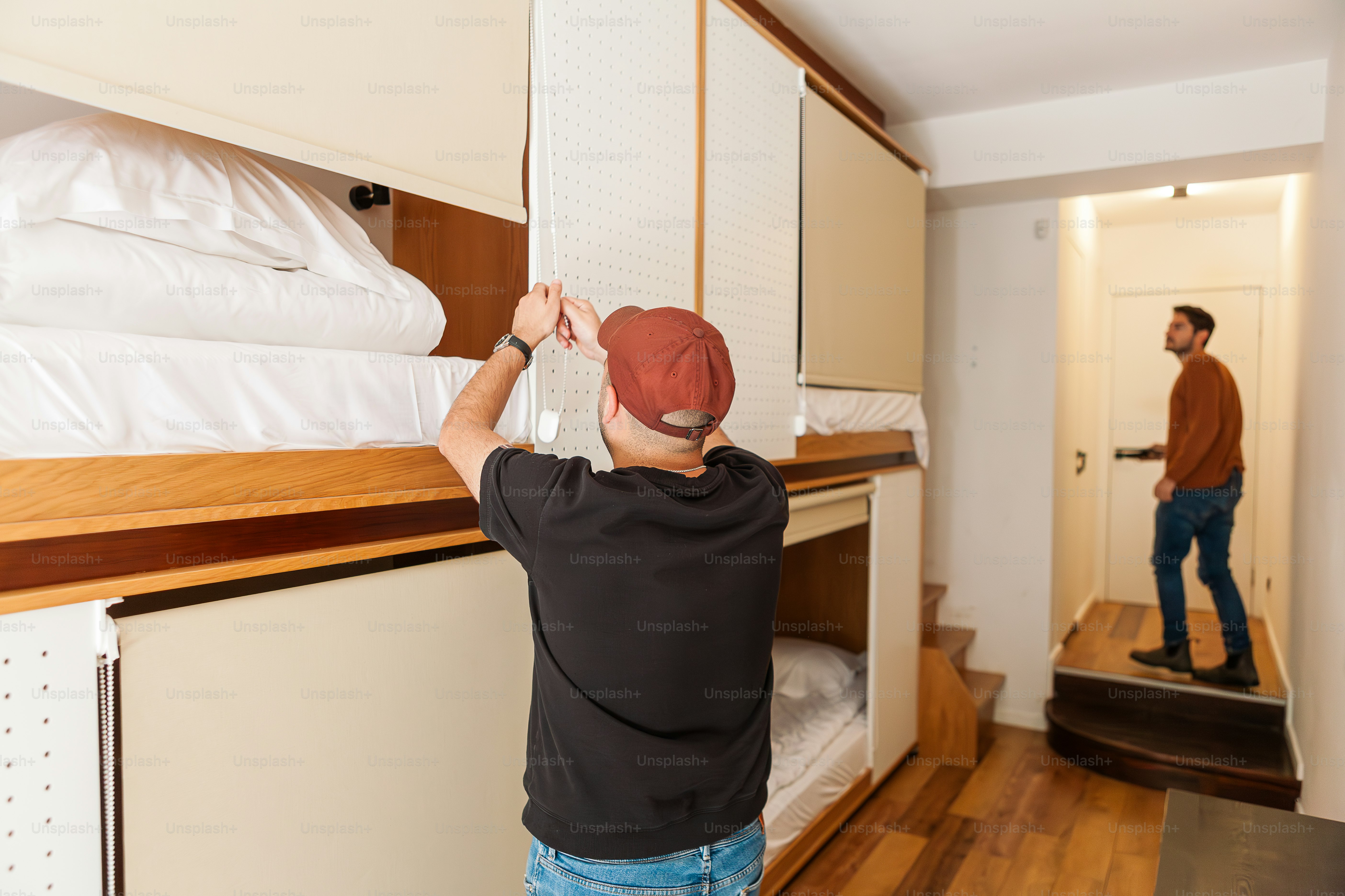 a man standing next to a bed in a room