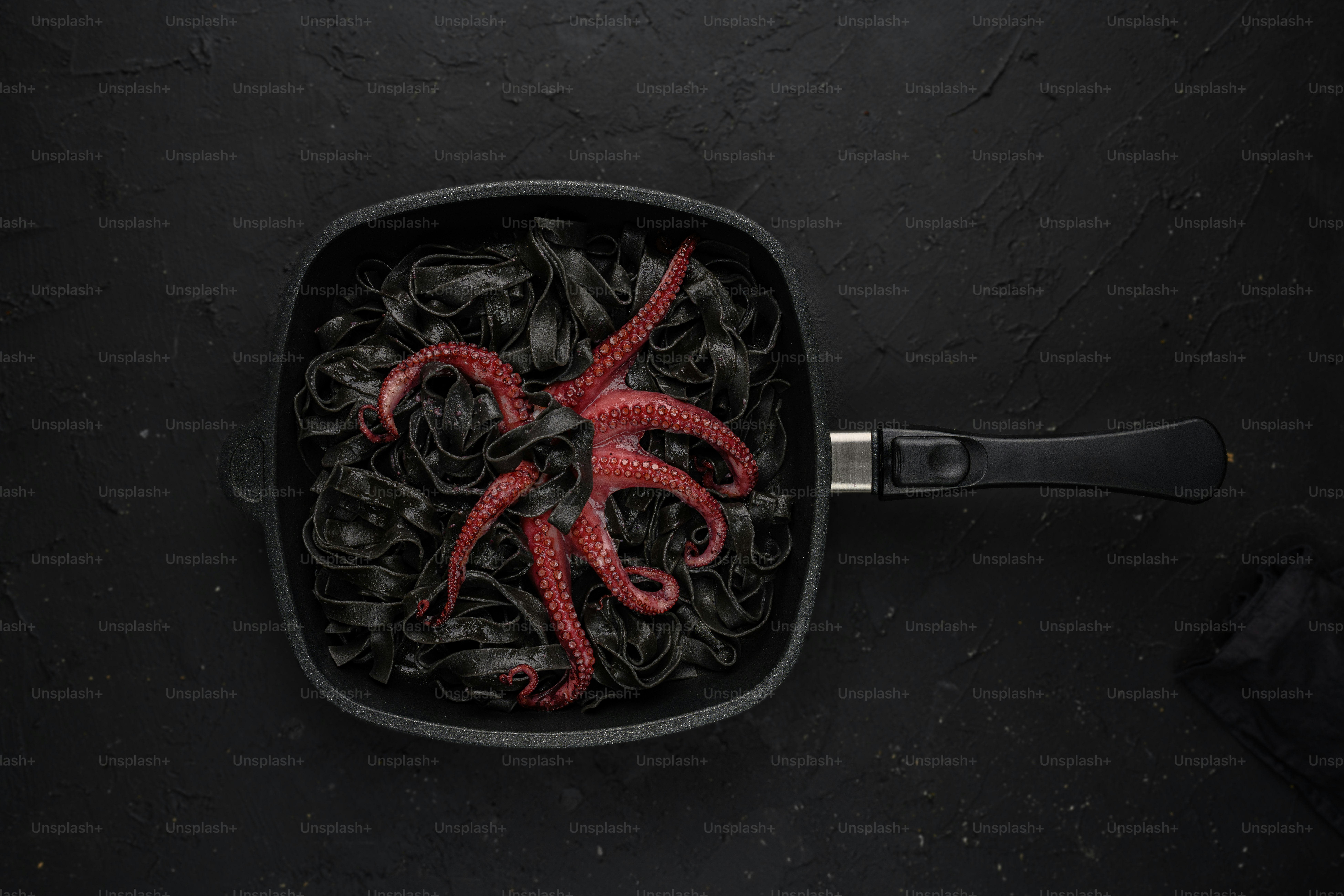 a bowl of noodles with a red octopus in it