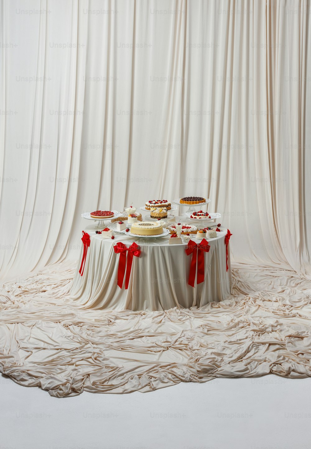 a table topped with cakes and desserts on top of a white table cloth