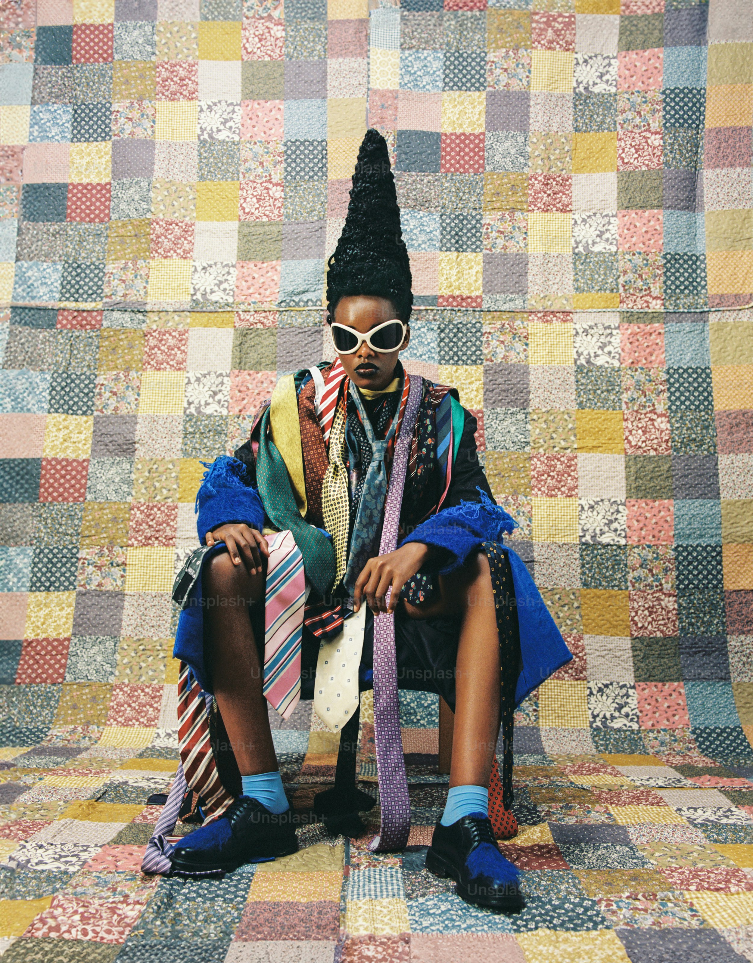 a woman sitting on top of a patchwork floor