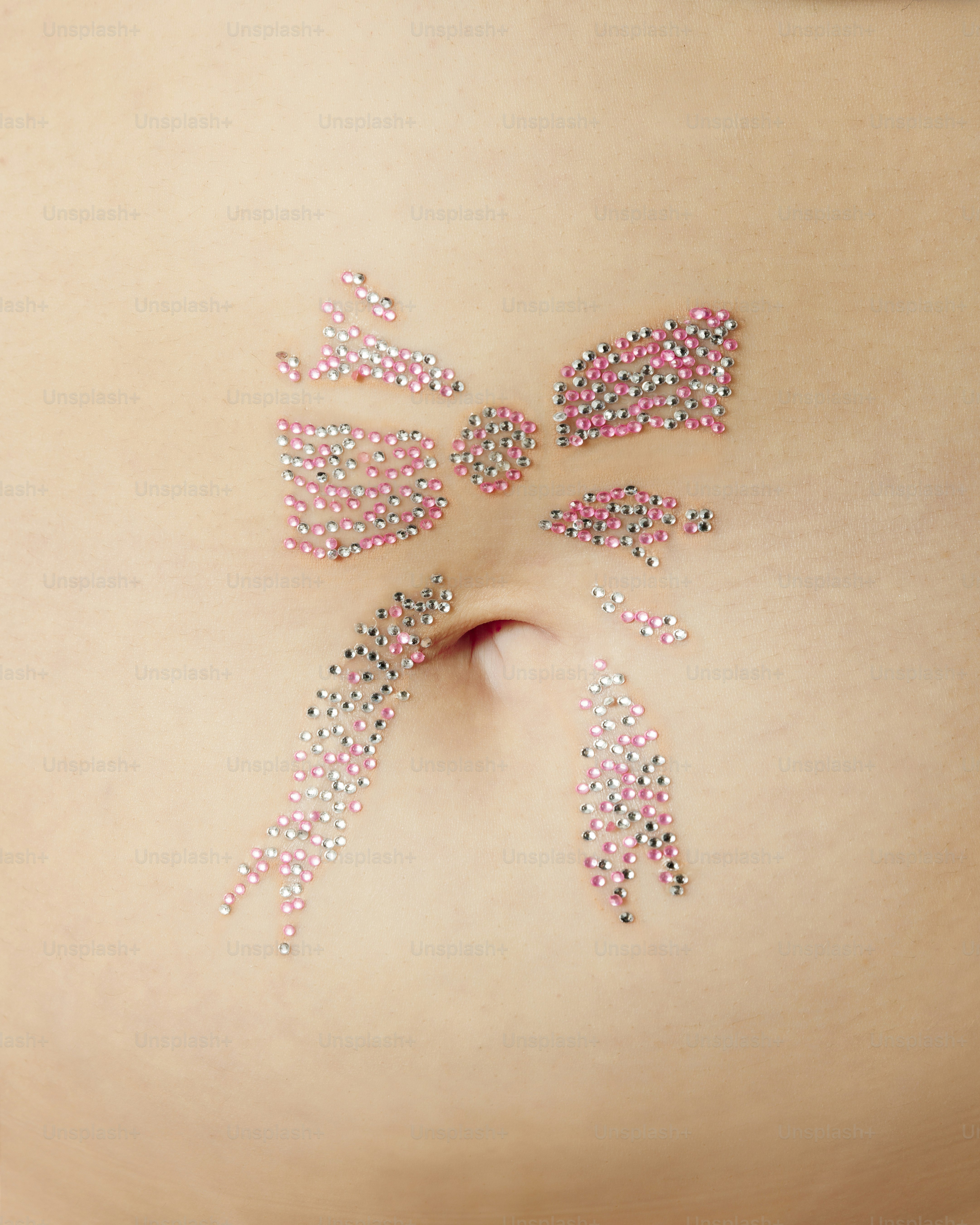 a woman's stomach with pink and white beads on it