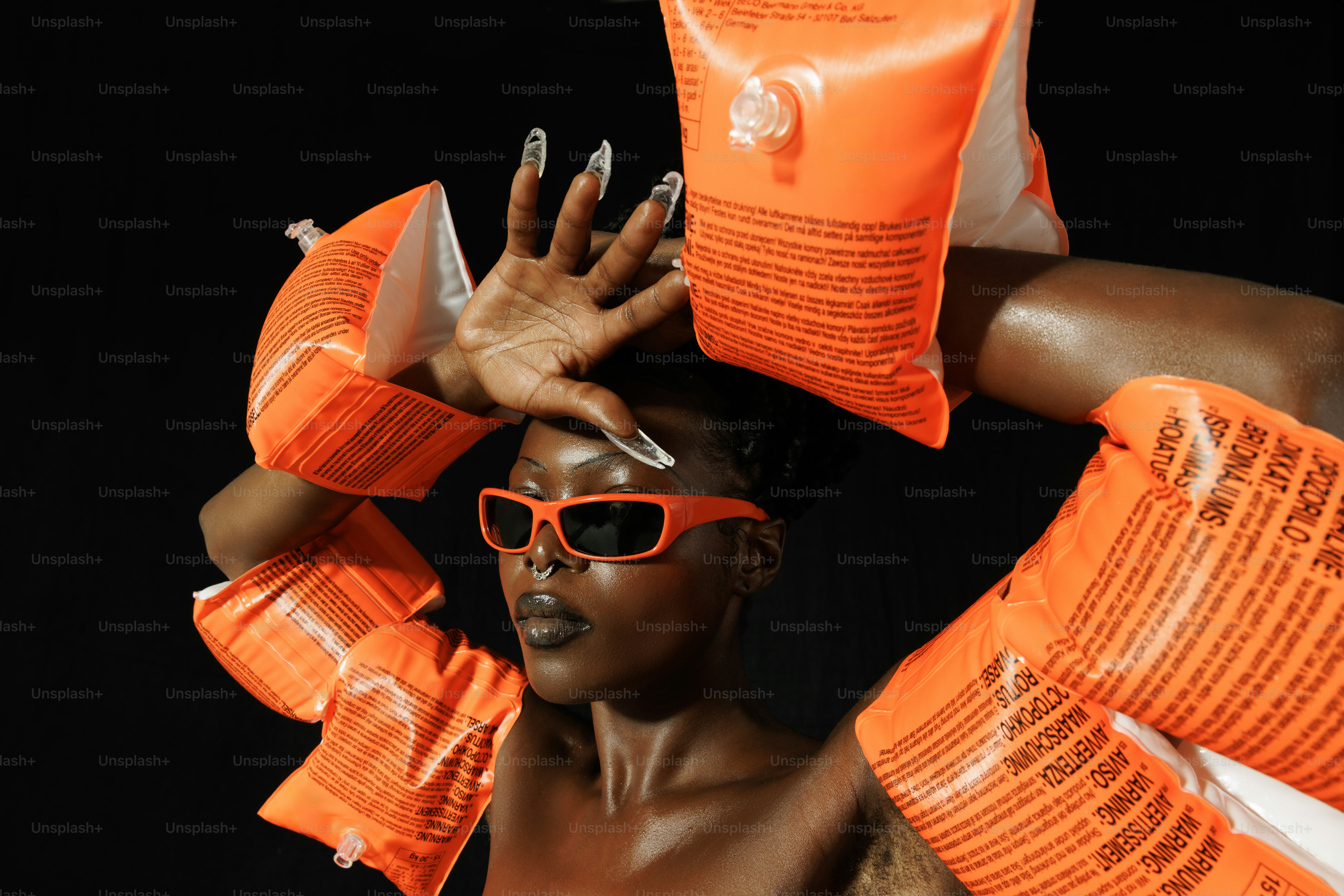 a woman wearing sunglasses and a bag of orange packets