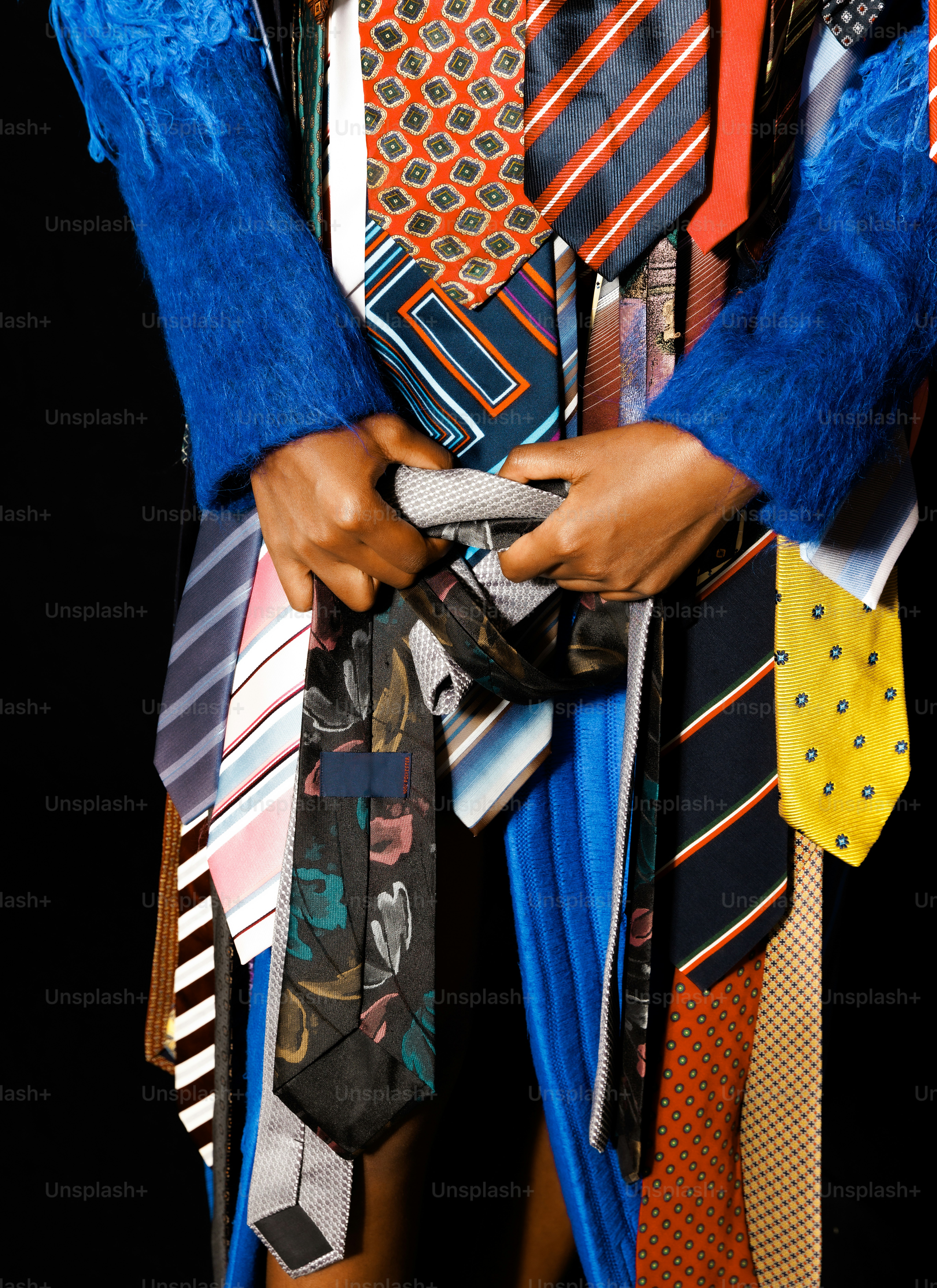 a person holding a bunch of ties in their hands