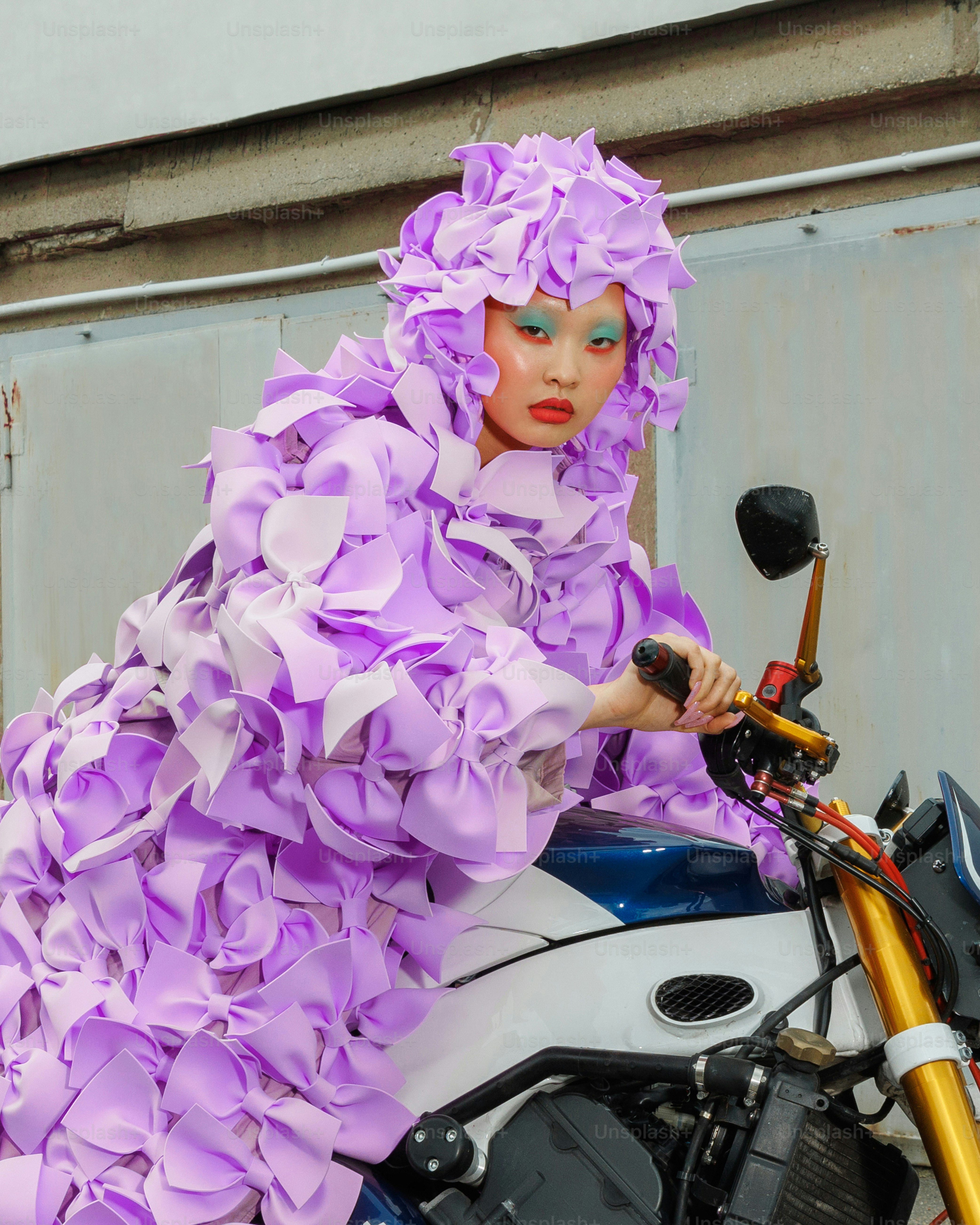 a woman in a purple dress sitting on a motorcycle