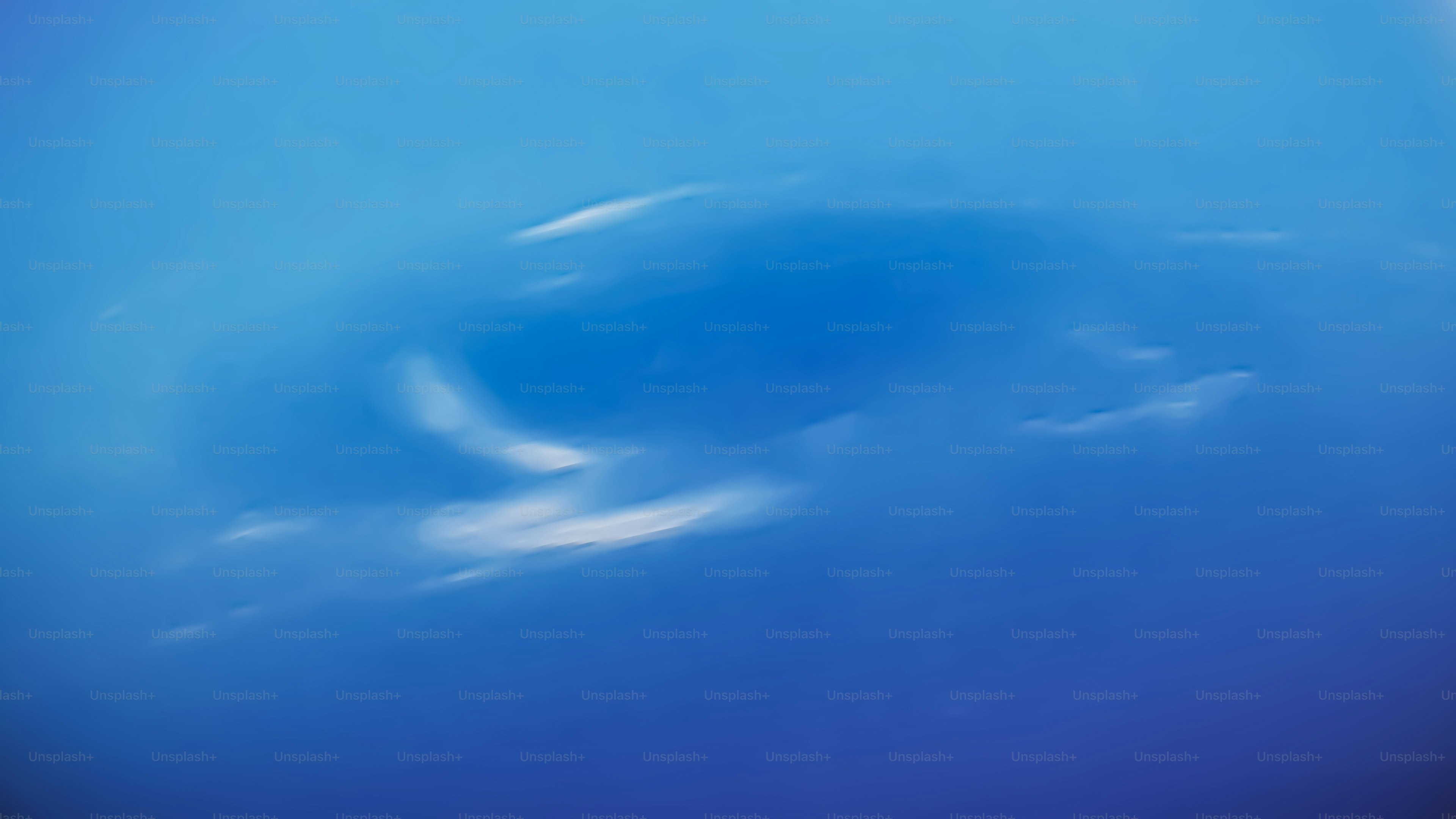 a blue sky with clouds and a plane flying in the sky