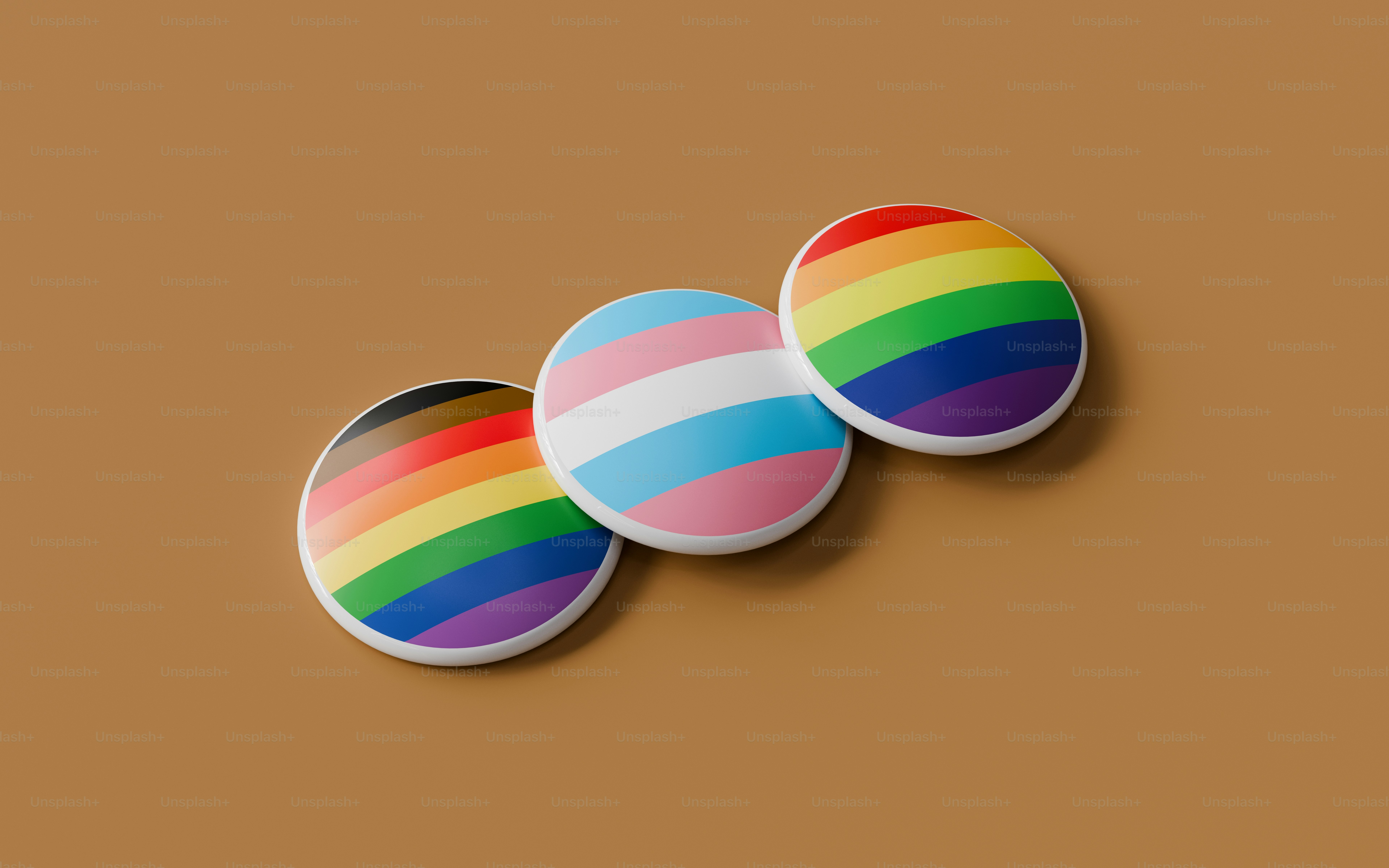 Three colorful buttons sitting on top of a brown surface photo – Pride ...