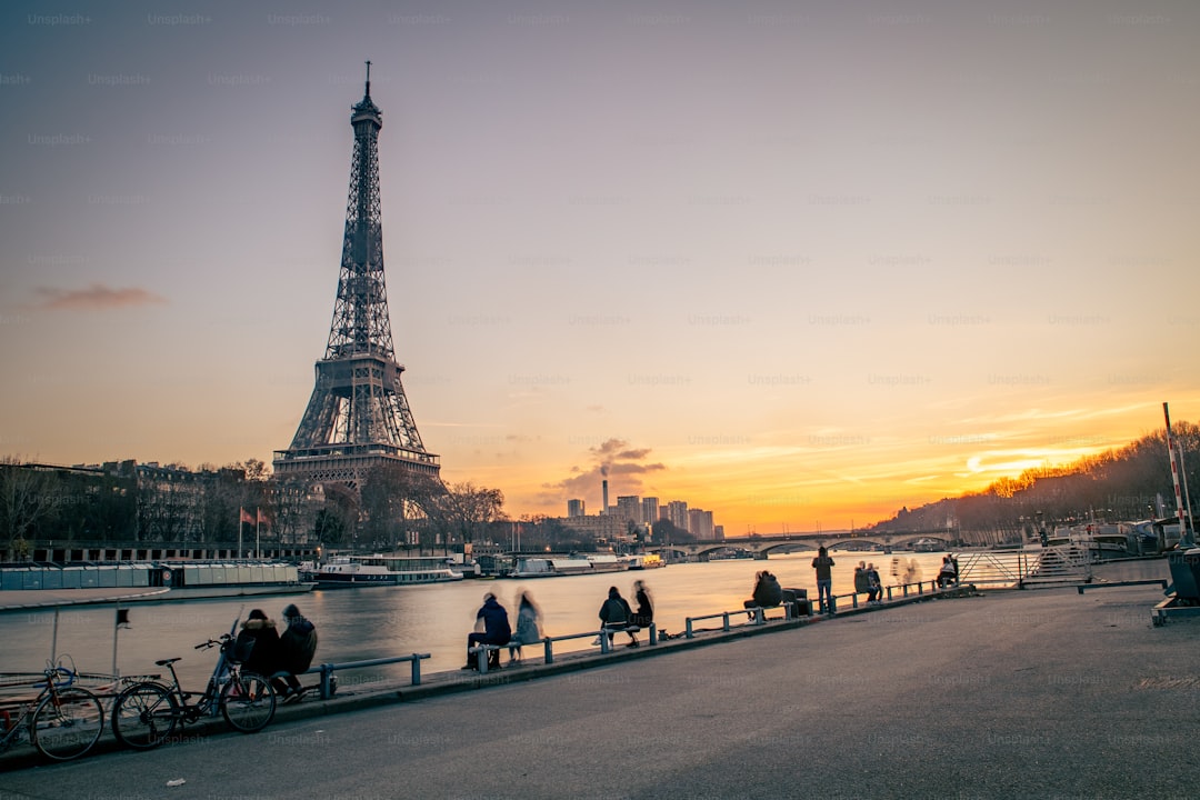a group of people standing next to the eiffel tower